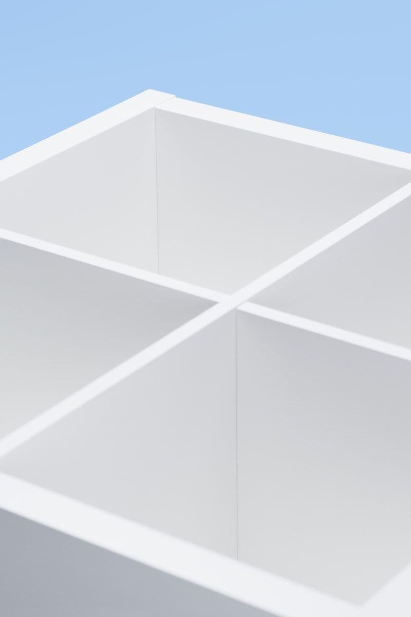 Elevated, close up view of a white KALLAX shelf unit lying on its side