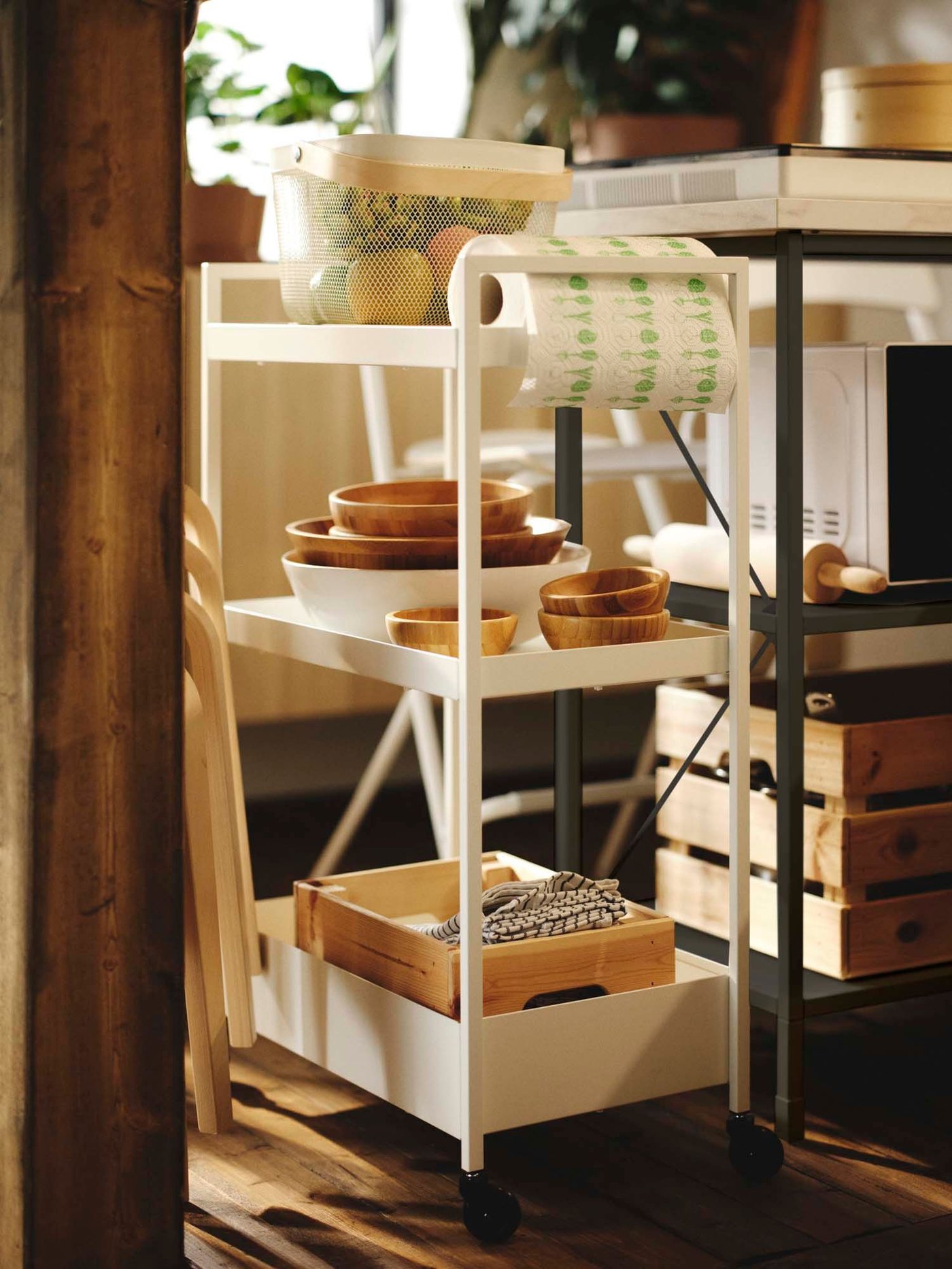Wooden bowls, a pine KNAGGLIG box, and a white RISATORP basket on a white NISSAFORS trolley in a kitchen environment.