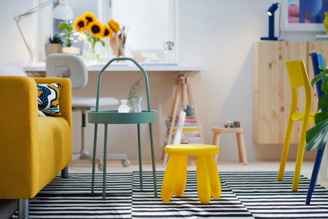 A bright and cheerful living room with yellow KLIPPAN sofa, green-grey BURVIK side table and yellow MAMMUT children's chair.