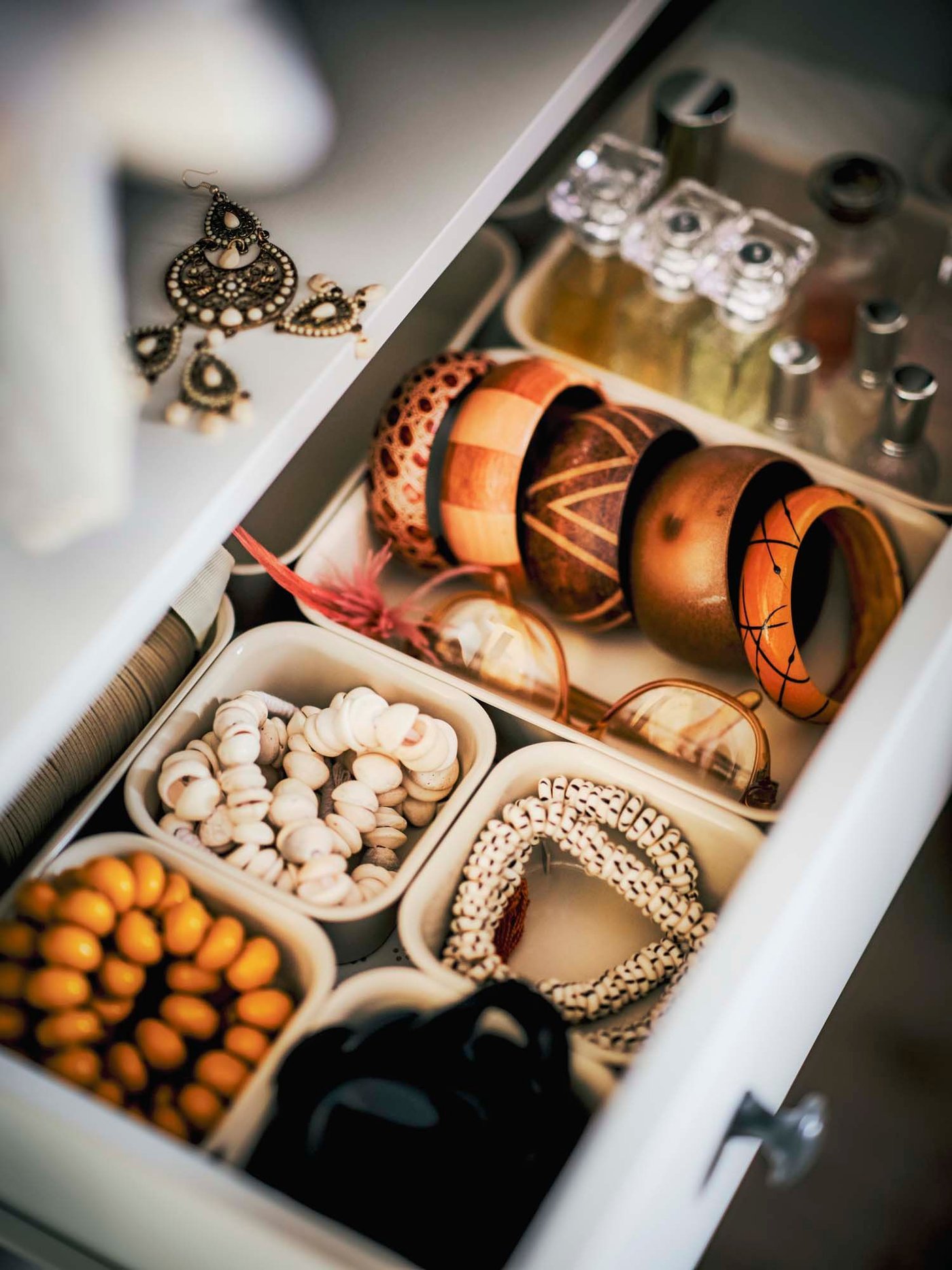 Overview of an open dresser drawer with jewellery stored in NOJIG organisers.