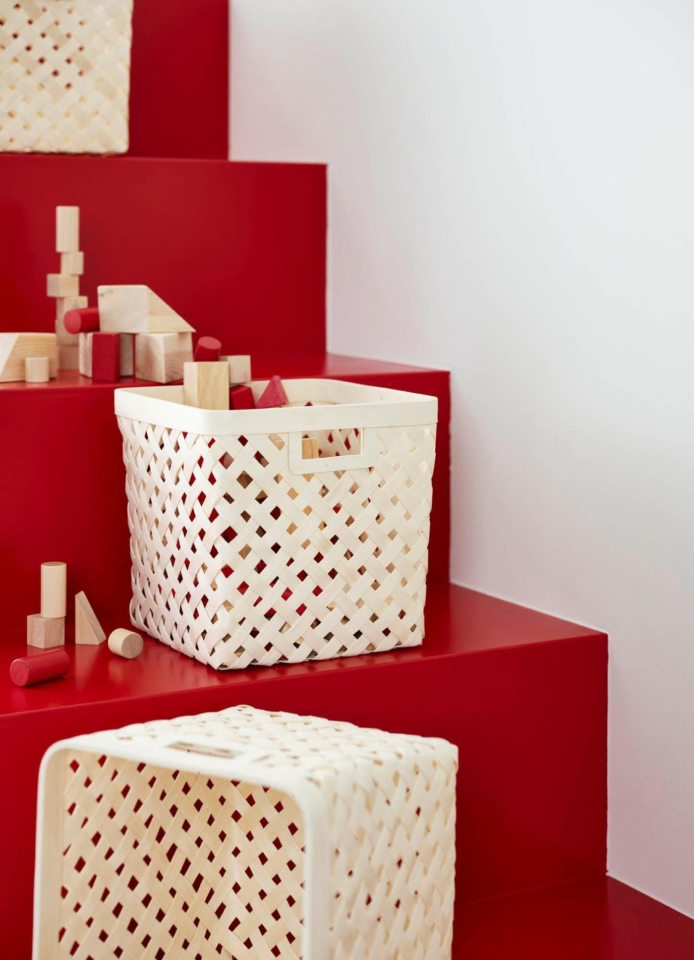 VÄXTHUS baskets made from woven poplar on the steps of a red staircase.