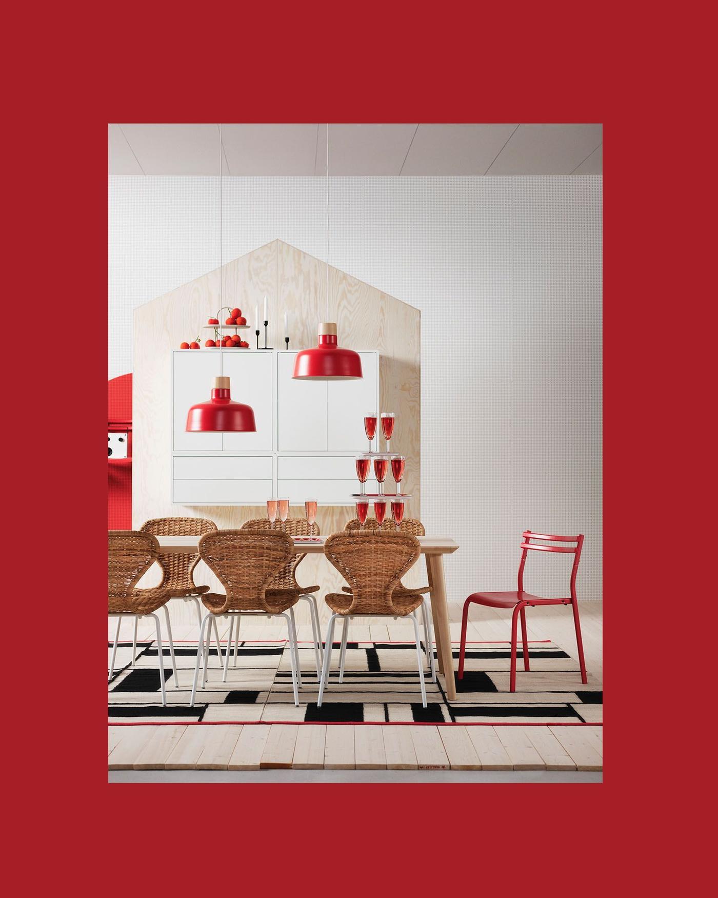 A thick red frame containing the image of a dining area with two red pendant lamps hanging over a table with a pyramid of stacked red drinks.
