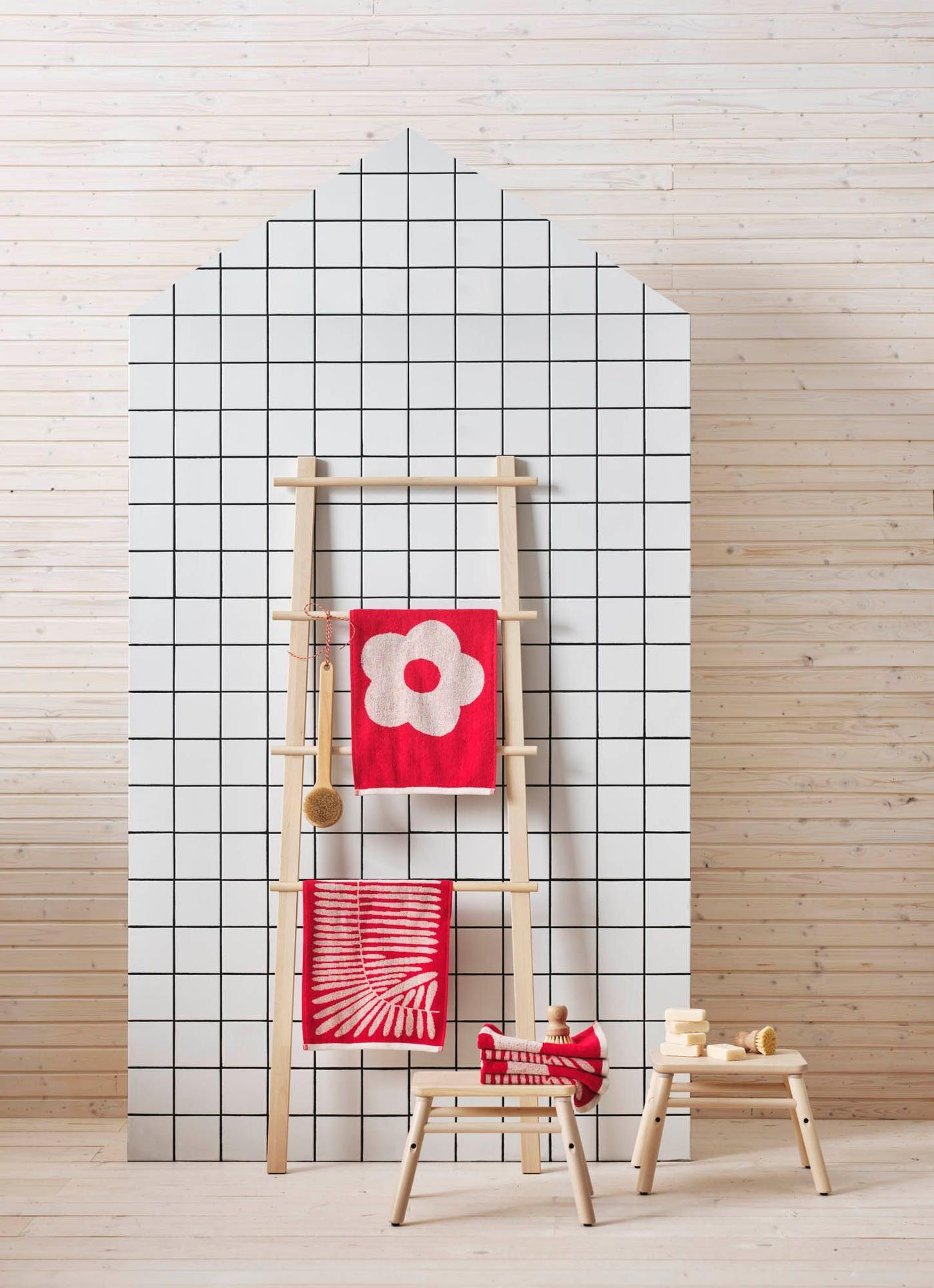 MAJSMOTT guest towels styled on wooden stools and ladders against a white-tiled backdrop.
