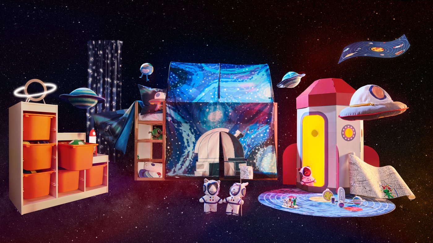 Two toy animal astronauts stand in front of a bunkbed covered in a space inspired tent, a play rocket and storage units. 