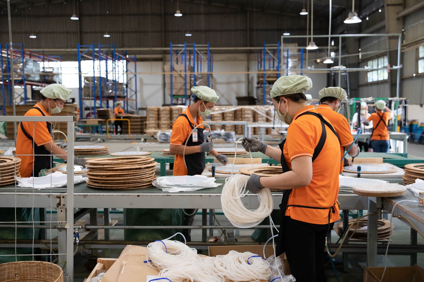 People working at a factory making woven home furnishing products.