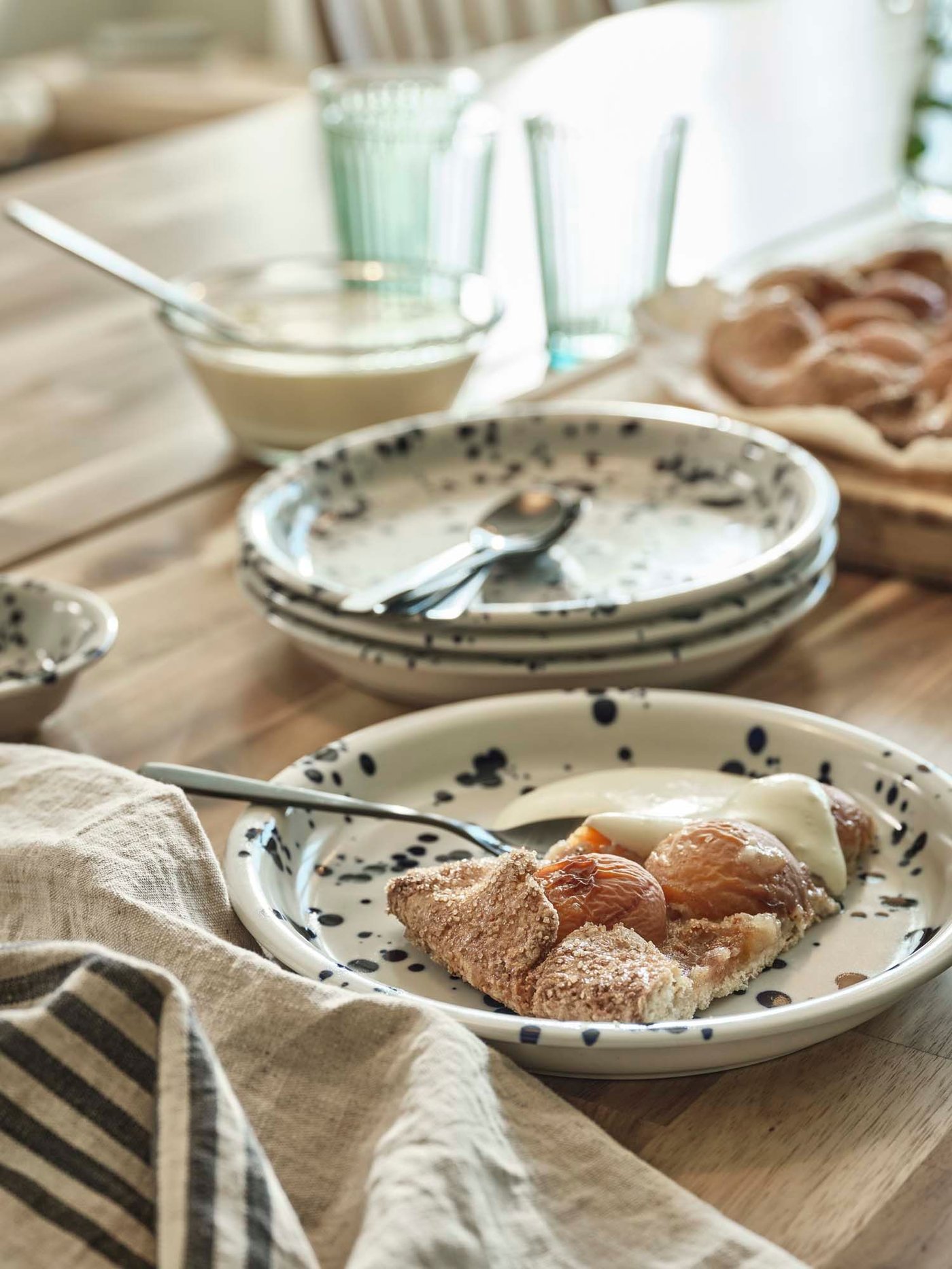A table set with SILVERSIDA plates, on which apple pie with cream is served.