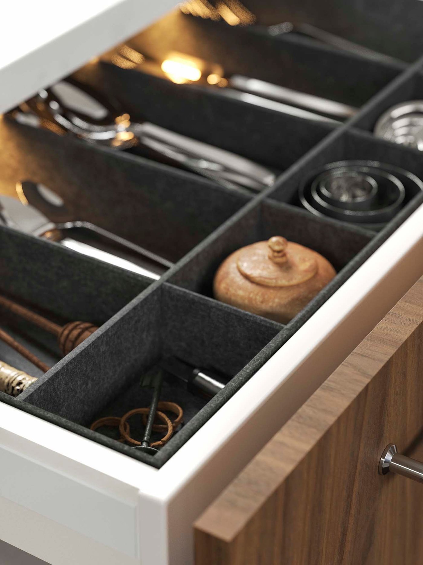 An open kitchen drawer with cutlery organised in a grey UPPDATERA adjustable organiser for drawer.