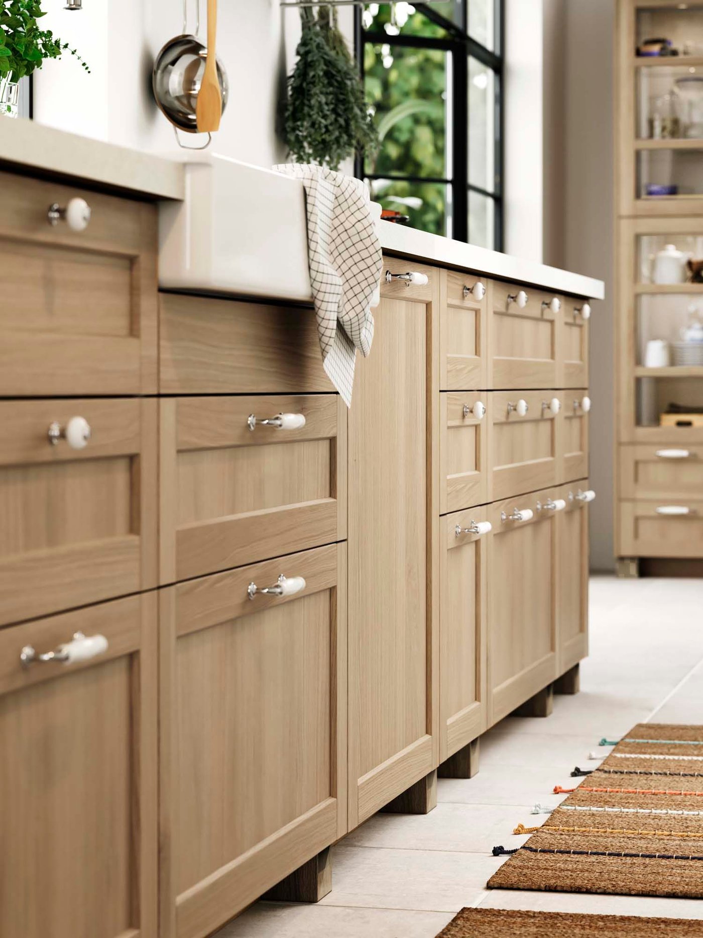 Wood FORSBACKA doors and drawers with traditional KLINGSTORP chrome mand porcelain-effect handles in a kitchen.