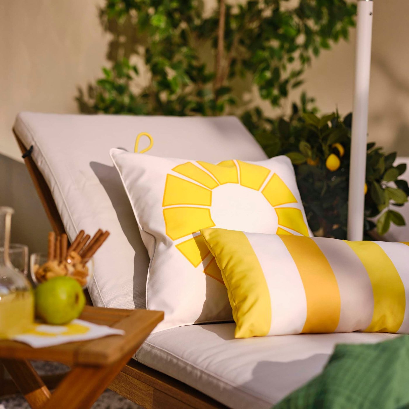 A yellow BRÖGGAN back cushion, in/outdoor and another cushion in a BRÖGGAN cushion cover on a NÄMMARÖ sun lounger.