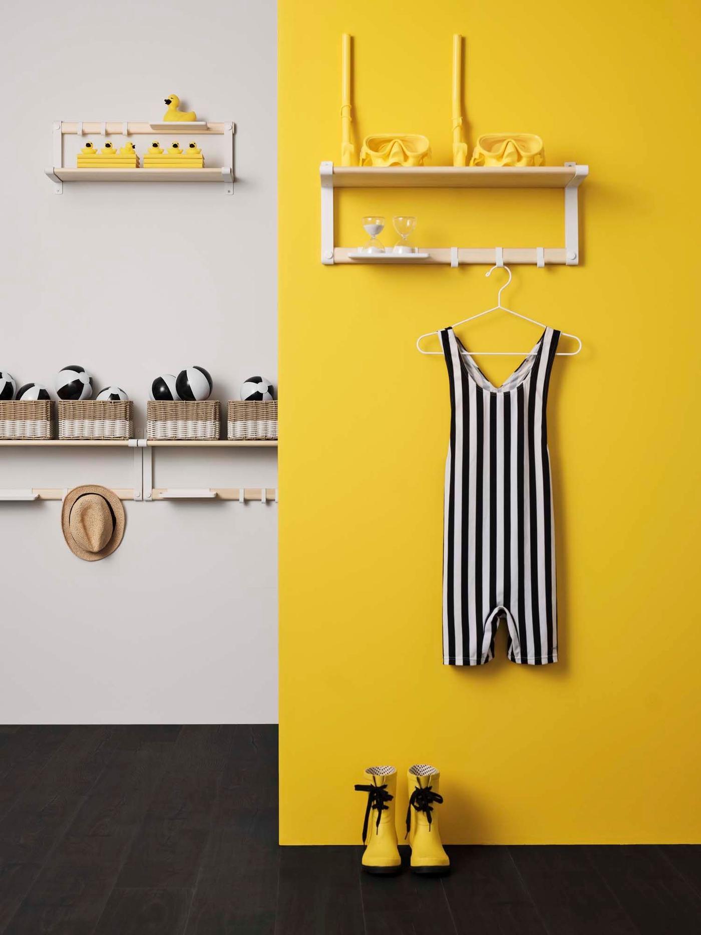 A roomset with a yellow wall. On the yellow wall is a clothes rack with a black and white onepiece, with yellow shoes below..