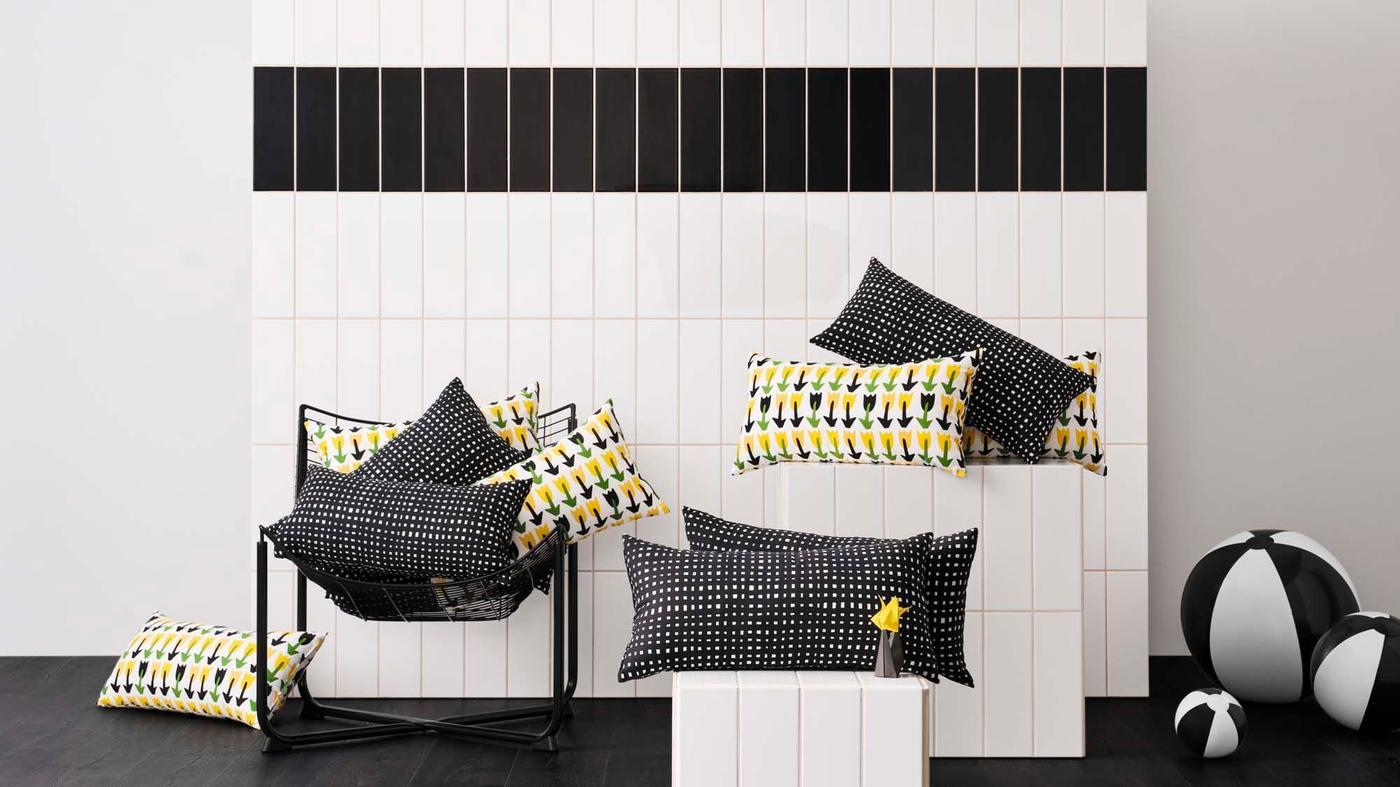 Cushions sit on podiums against a black and white tile backdrop.