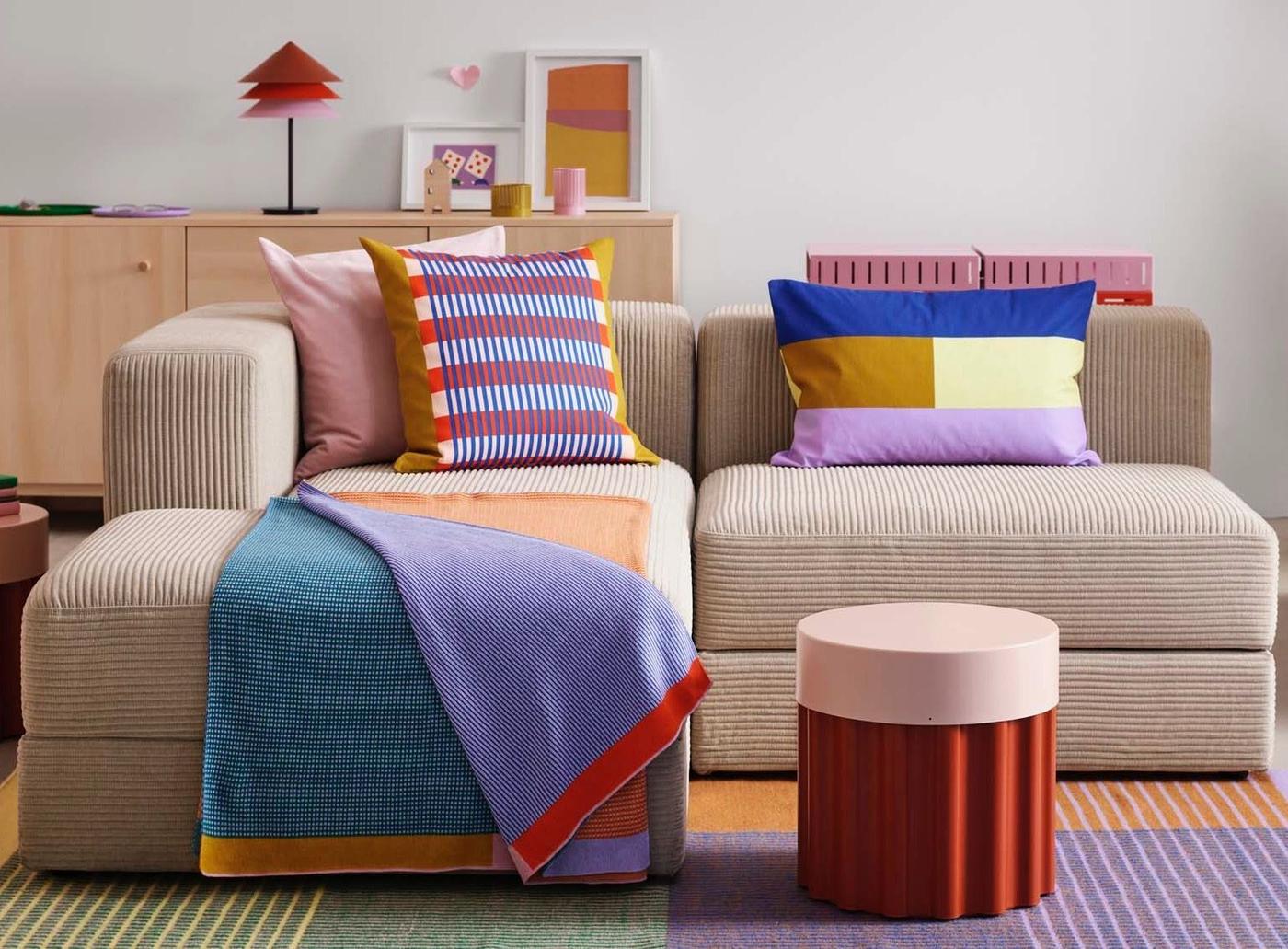 A TESAMMANS side table next to a modular sofa decorated in cushions in TESAMMANS cushion covers and a TESAMMANS throw.