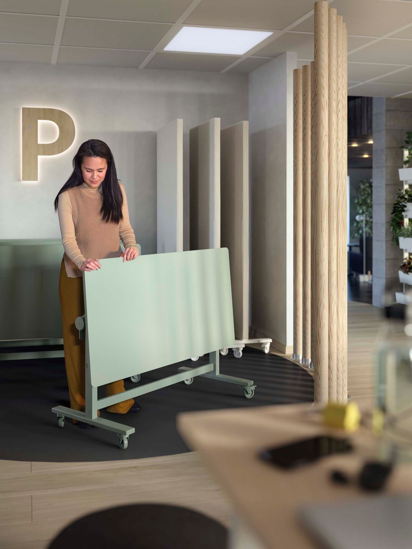 A person in an office unfolding a green MITTZON foldable table with castors.