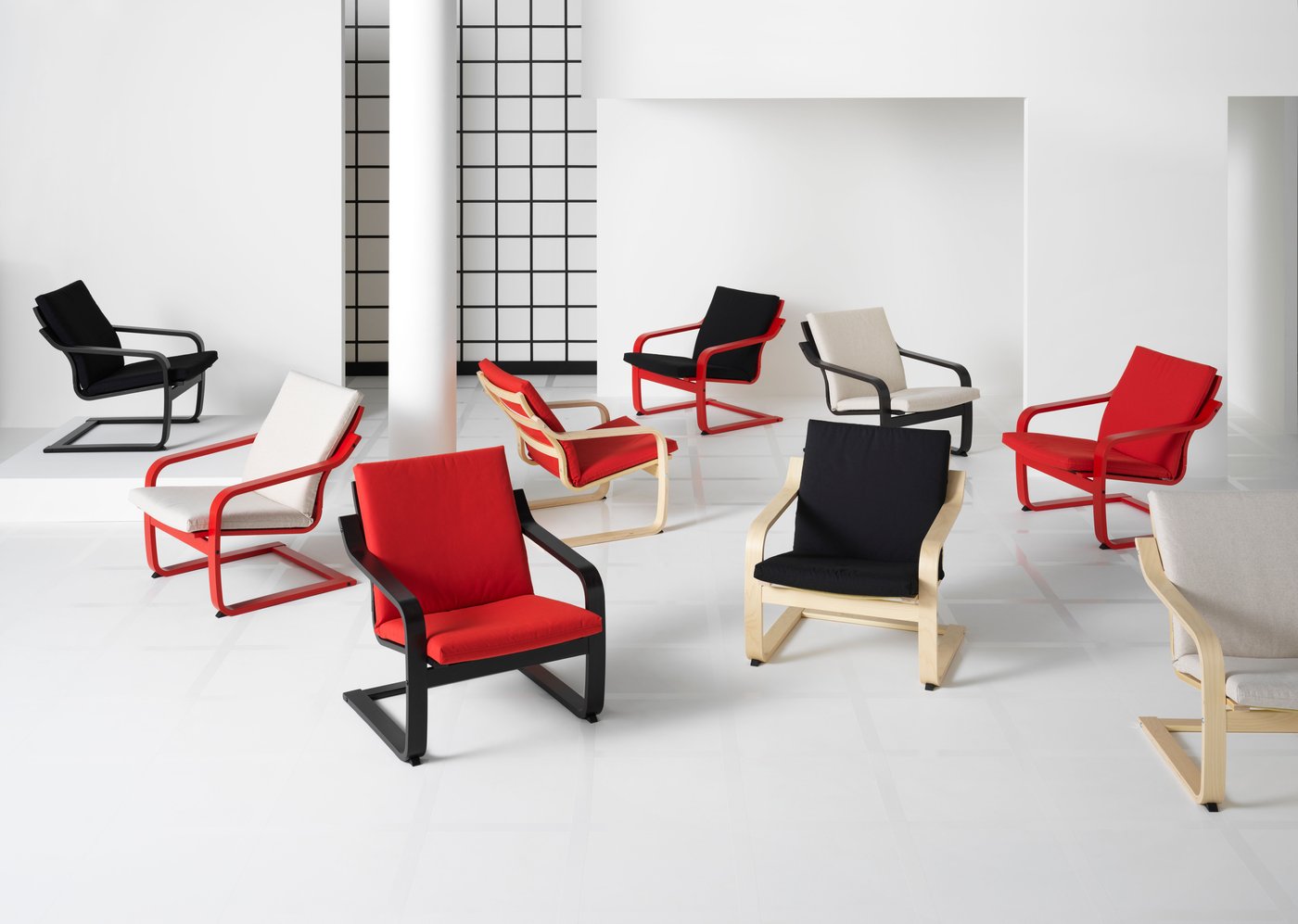 POÄNG chairs in different colours - red, black, white mixed together - are standing next to each other in a white room.