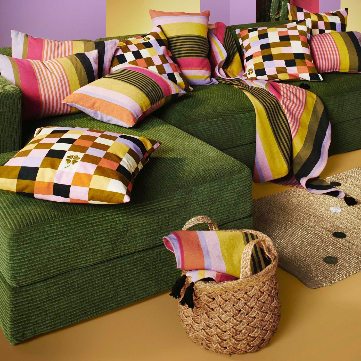 A samsala dark yellow-green JÄTTEBO 4,5-seat modular sofa covered in cushions in different MÄVINN cushion covers.