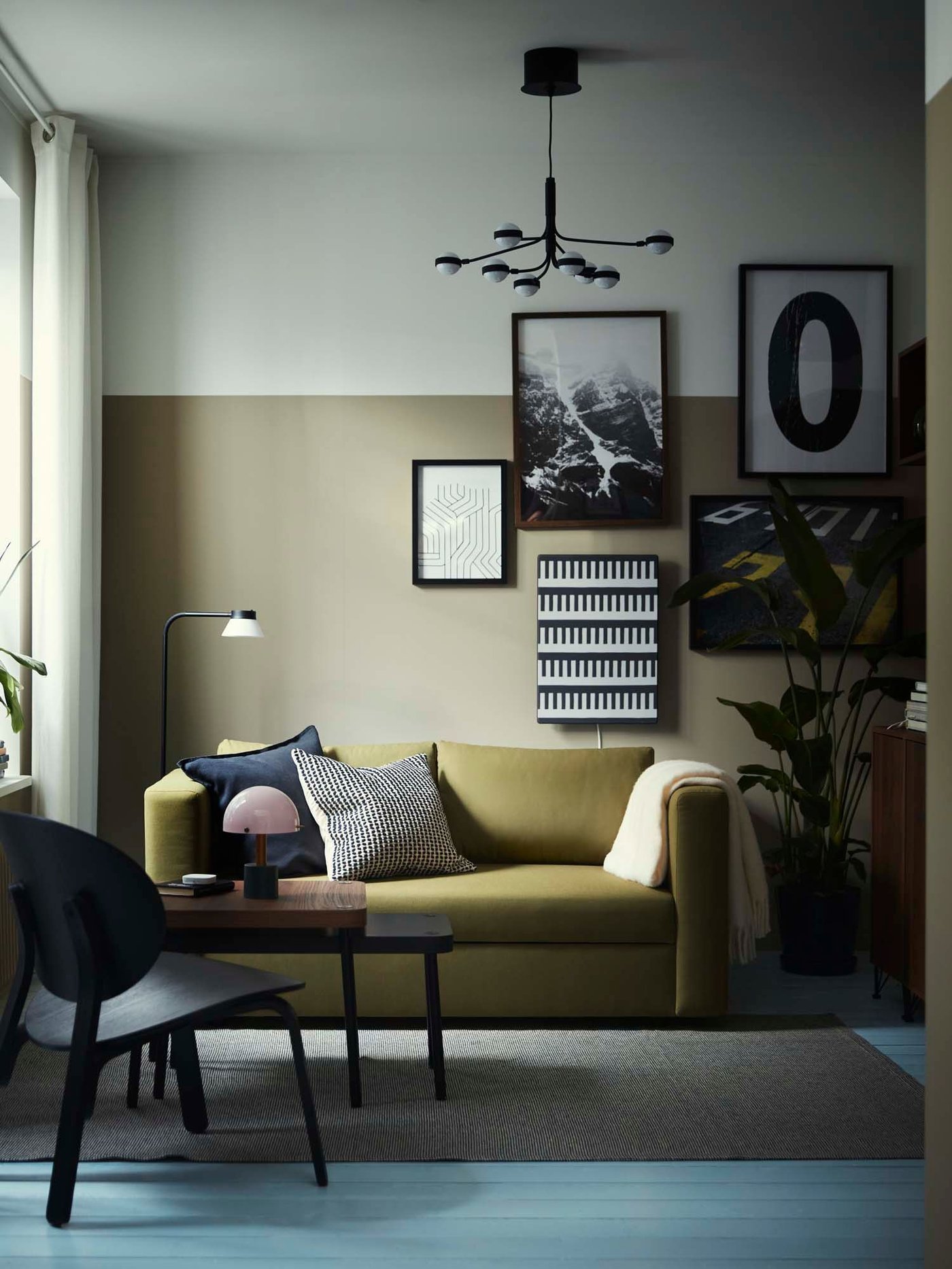 An olive green sofa bed in a green and white living room.