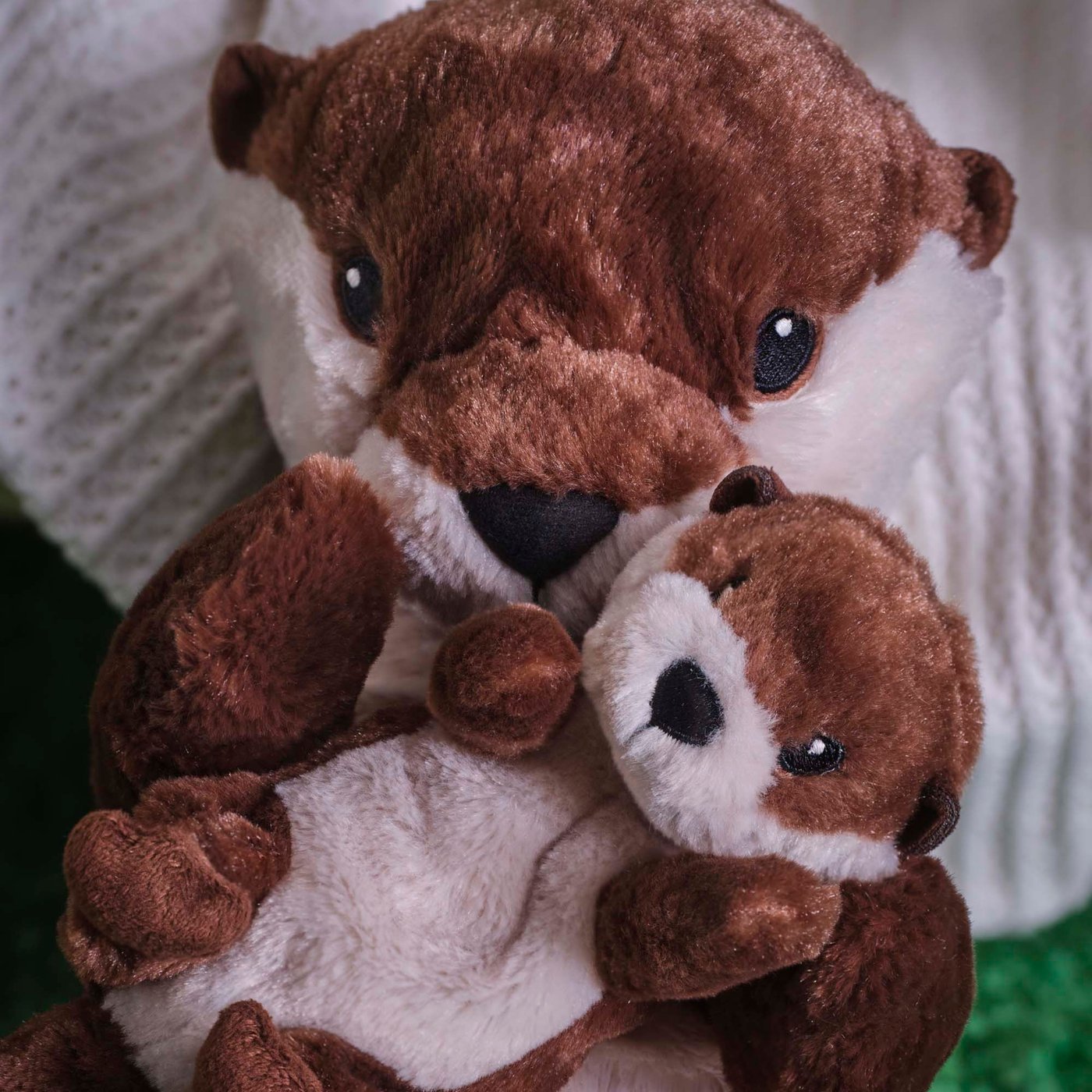 A closeup of an otter with baby/brown beige SKOGSDUVA soft toy.