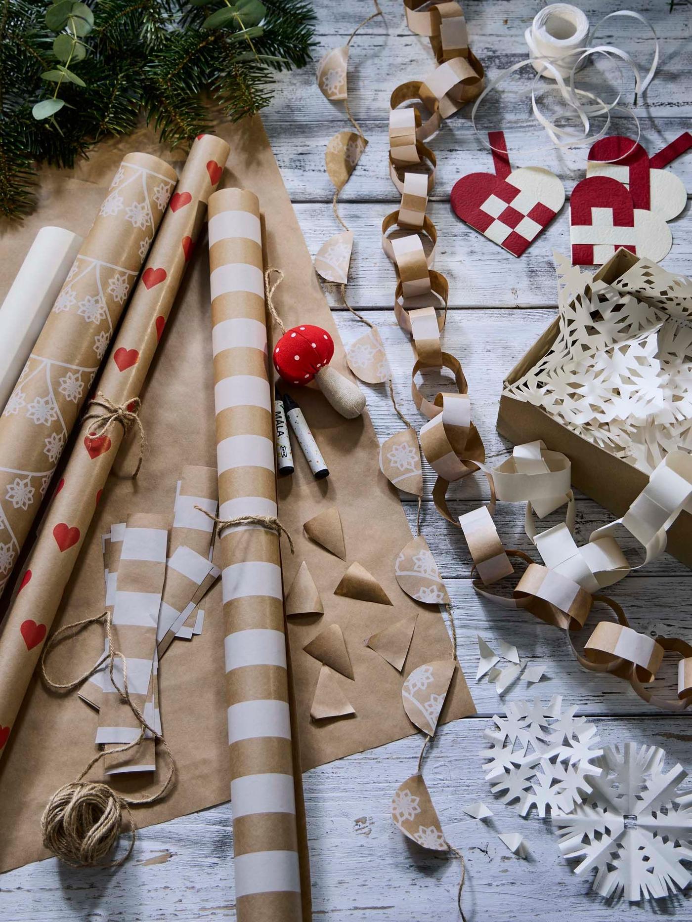 VINTERFINT gift wrap rolls and ribbons with paper garlands made from VINTERFINT gift wrap roll on a wooden surface.