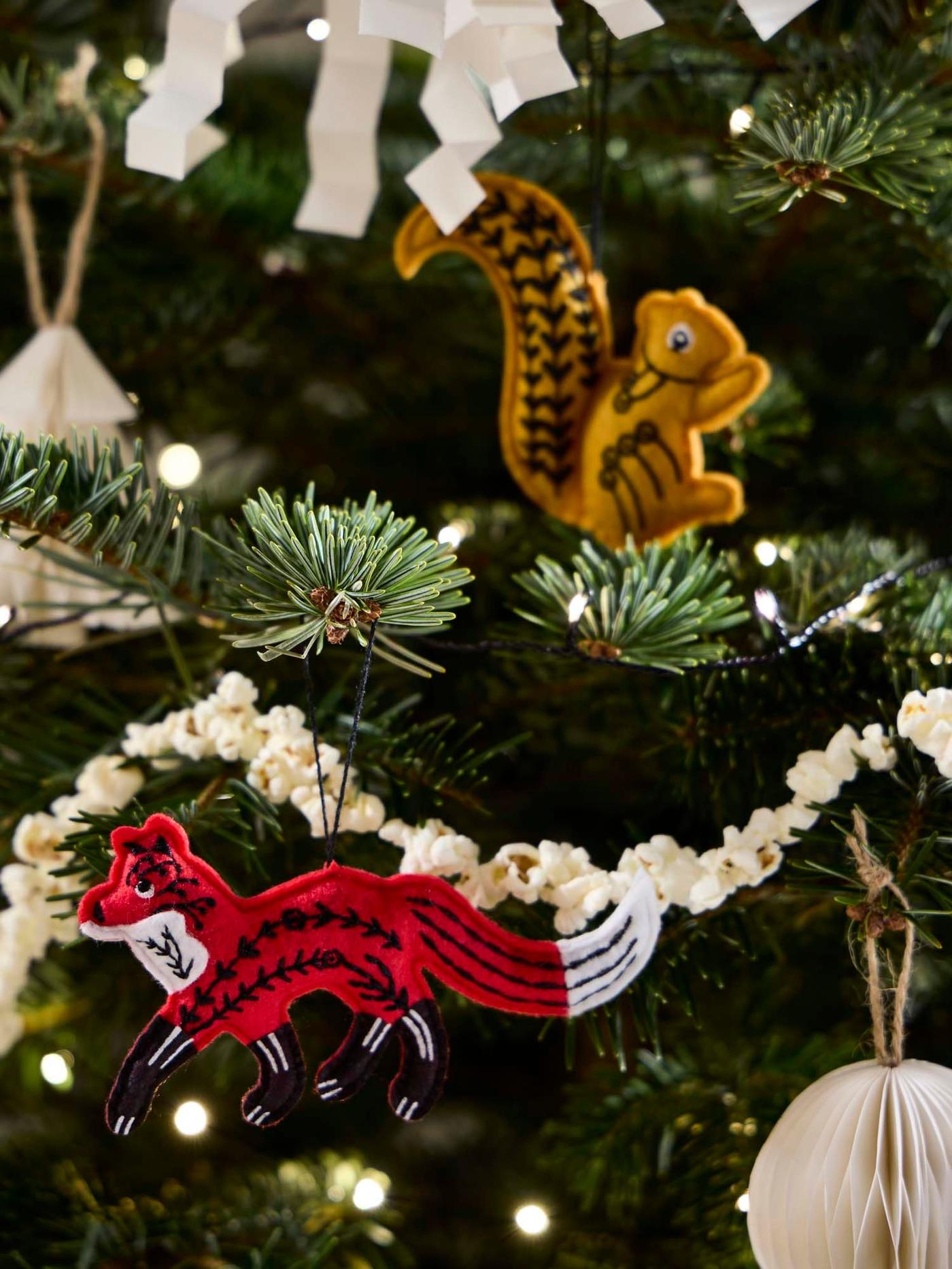 A close-up of a VINTERFINT artificial tree with various VINTERFINT tree ornaments hanging from its branches.