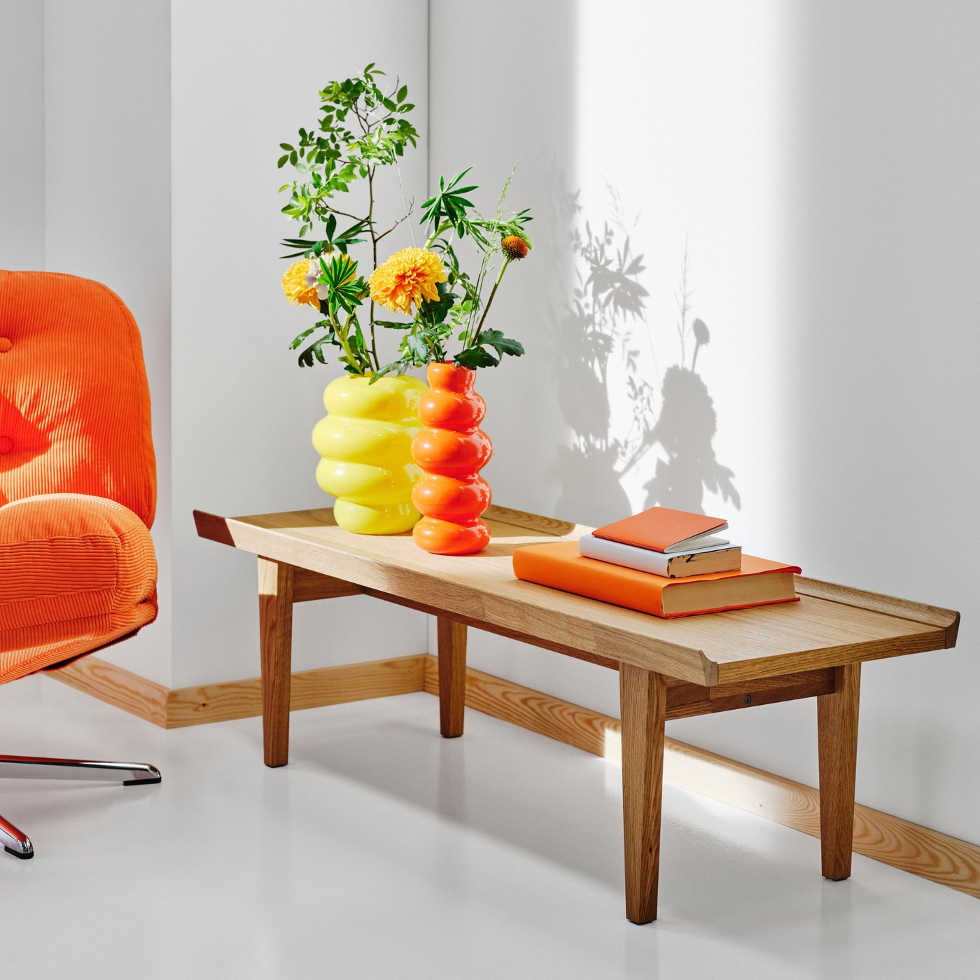 The image shows a set of new items from the 6th drop of Nytillverkad collection, including a table and a chair in orange color.