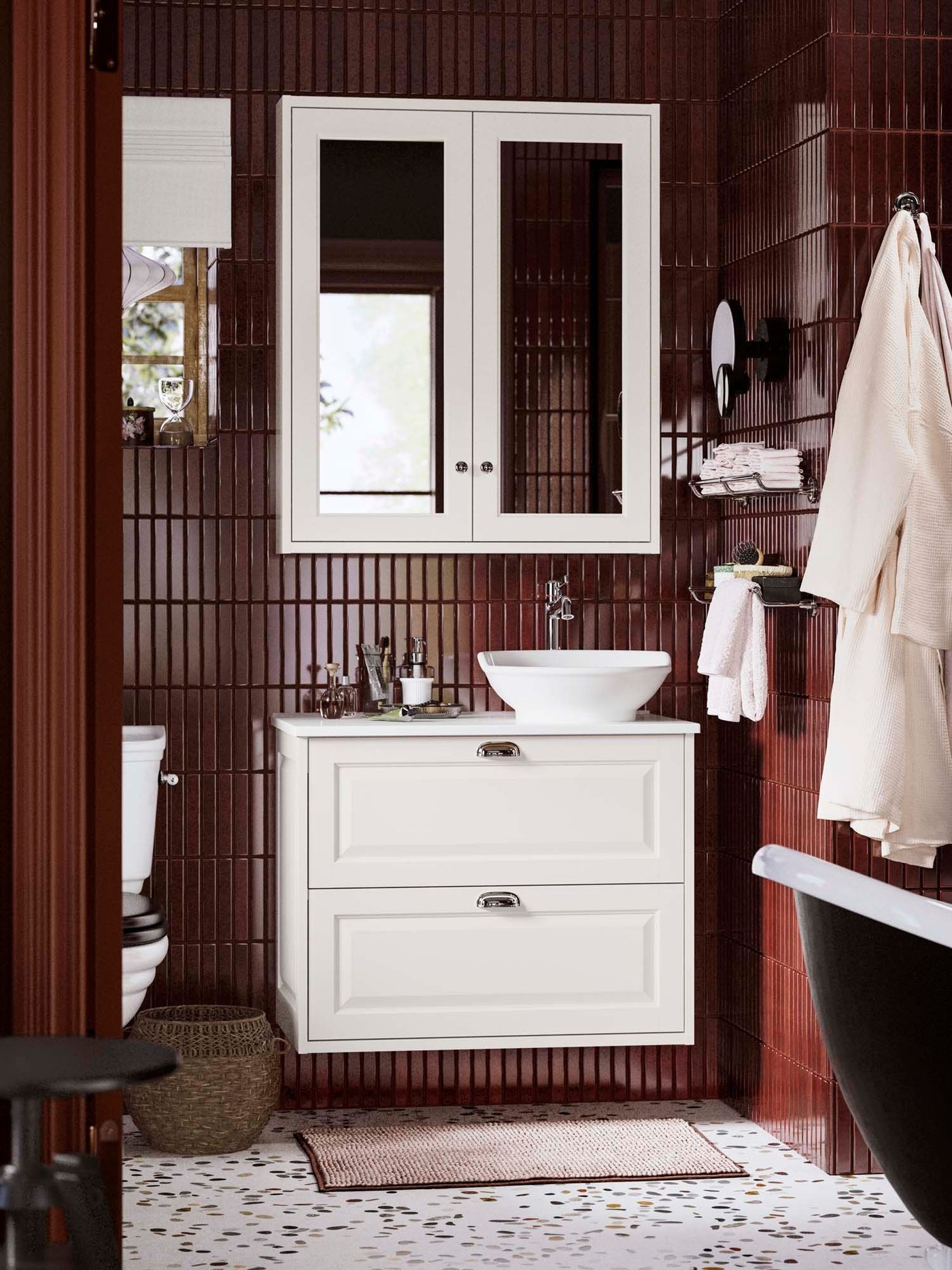 A TÄNNFORSEN wash stand and mirrored cabinet in white in a bathroom.