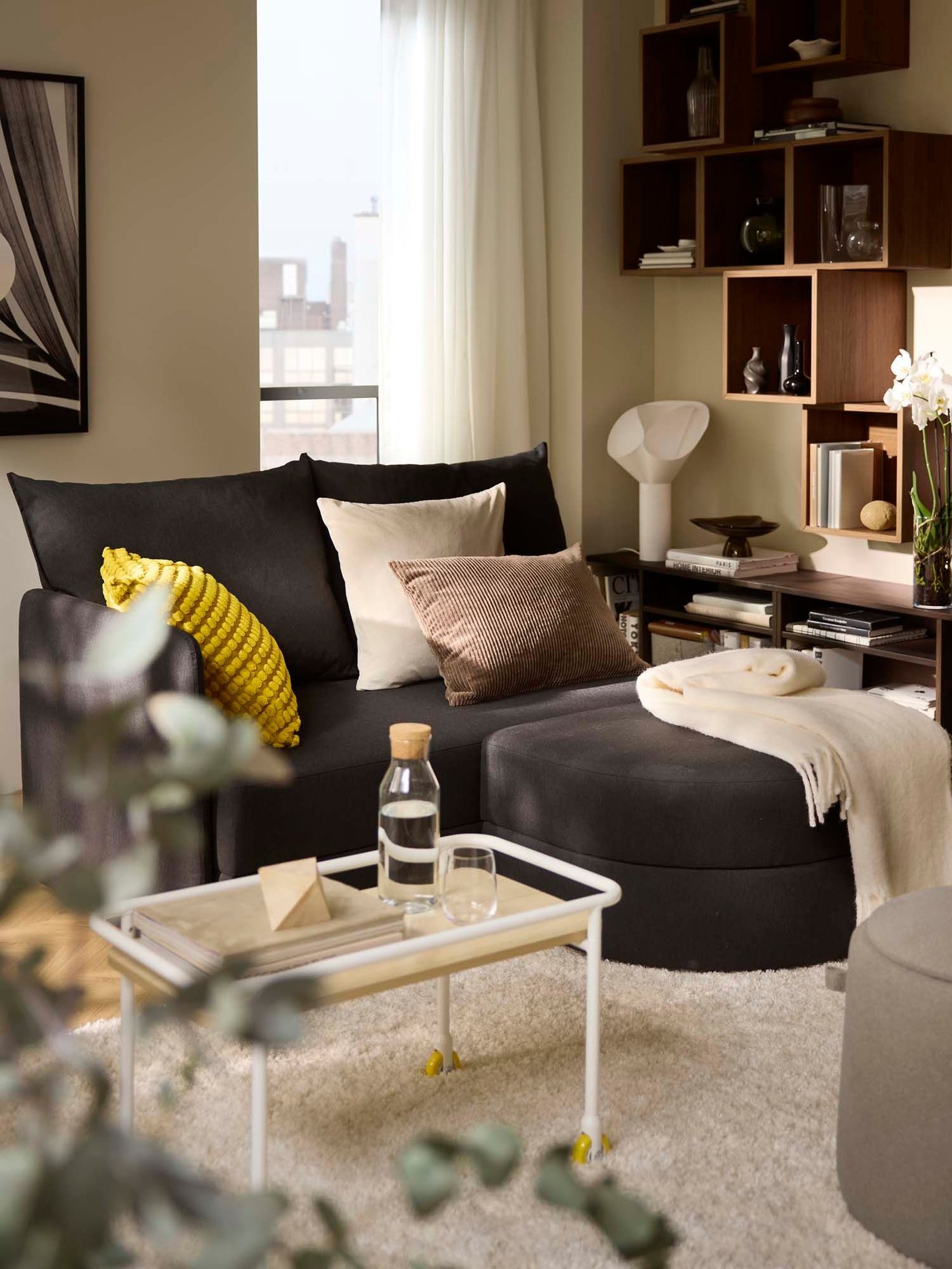 A dark grey sofa bed with footrest in a living room.