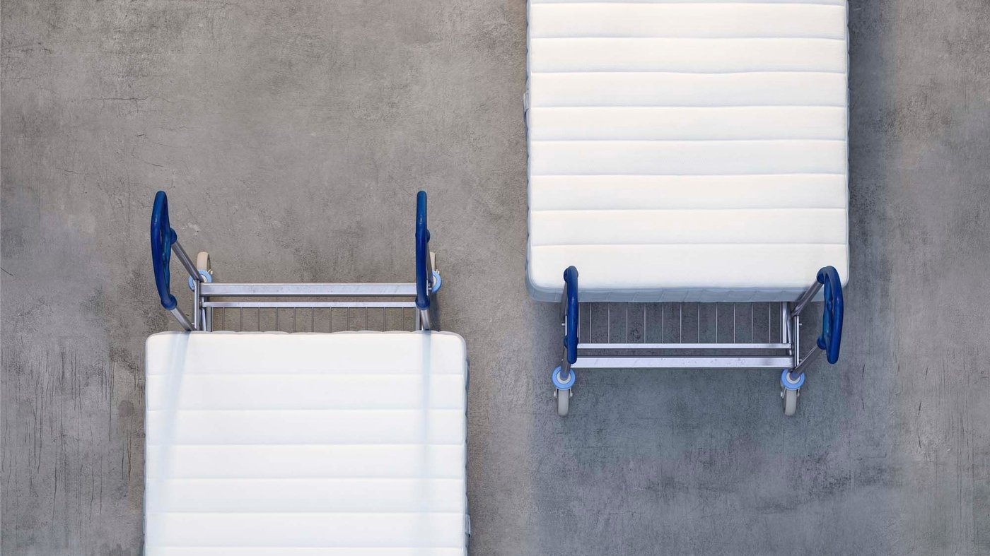 Aerial view of two mattresses, each on an IKEA trolley. They appear to be heading in opposite directions.