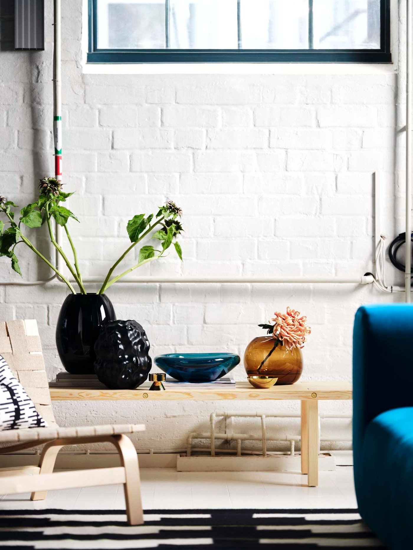 Beautiful coloured organic glassware on a light wood bench from the STOCKHOLM collection.