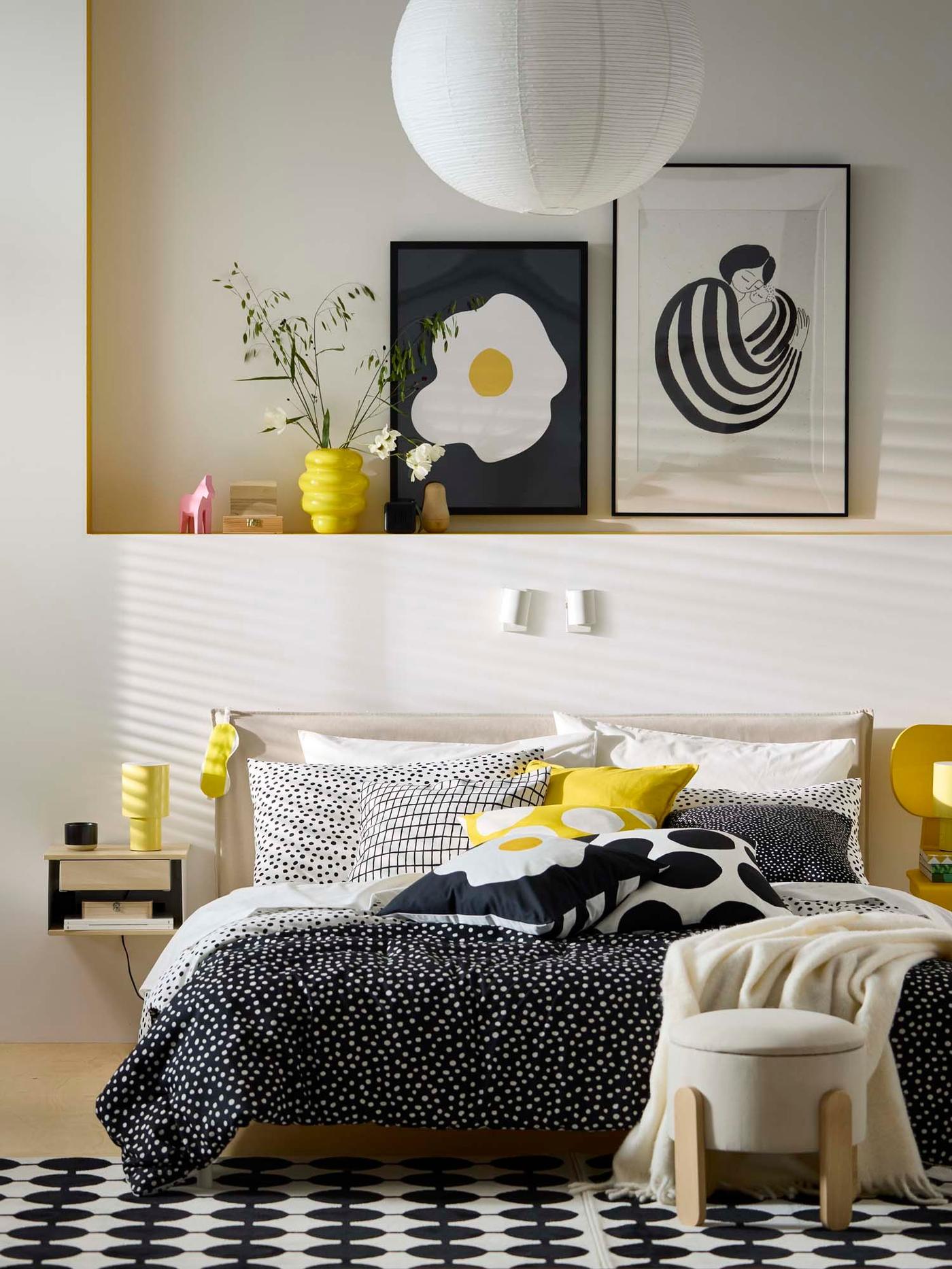 A neutral coloured bedroom with a bed with monochrome bed linen and matching artwork behind.