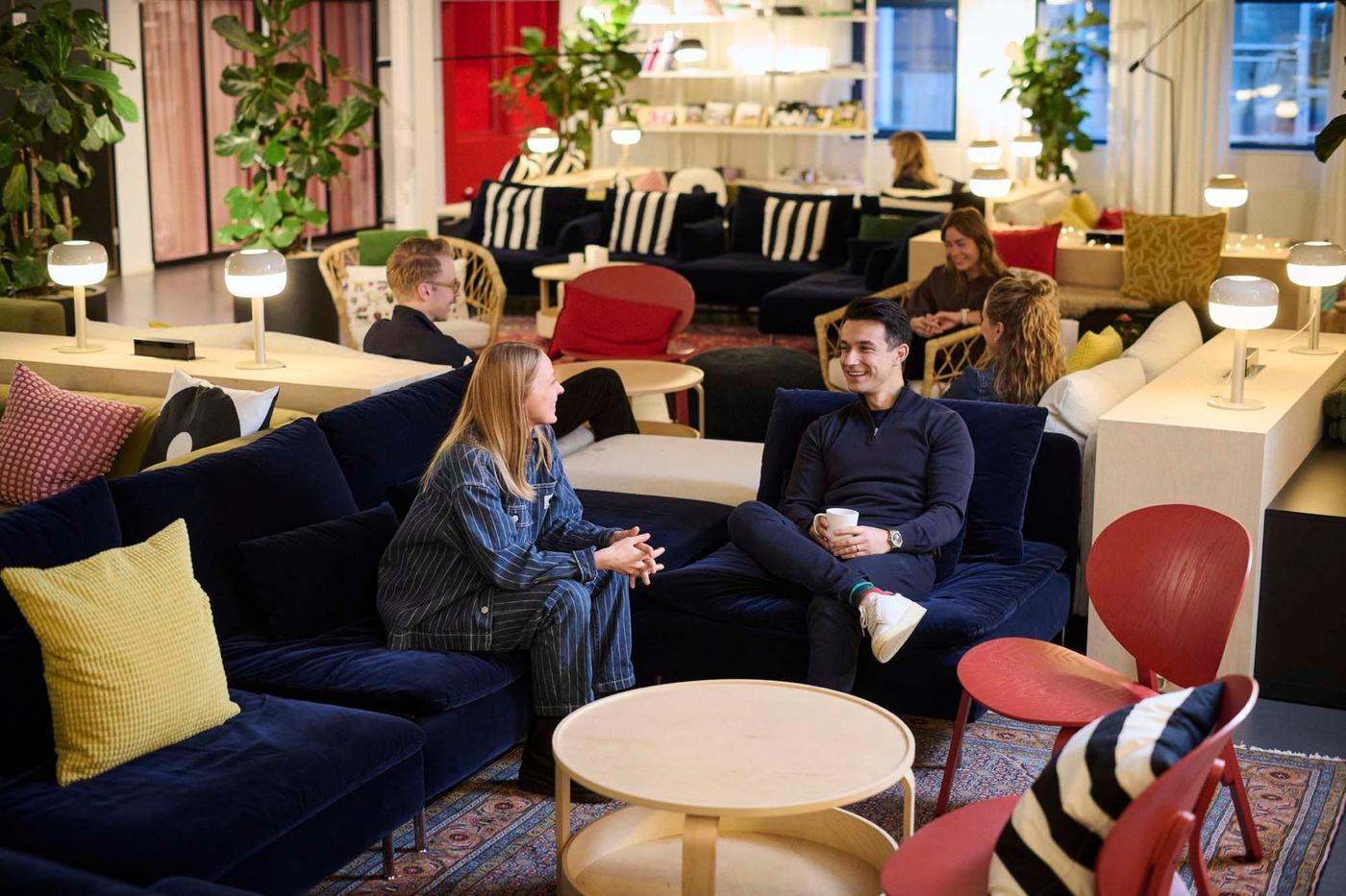 IMC colleagues sitting and chatting in a casual area with sofas, coffee tables and armchairs.