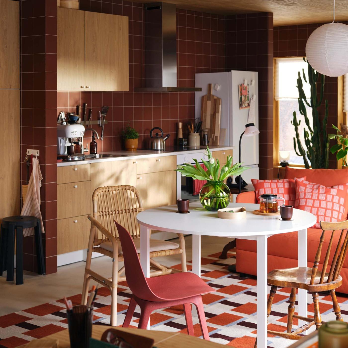A relaxed kitchen-dining area with a table and mismatched chairs in the foreground. 