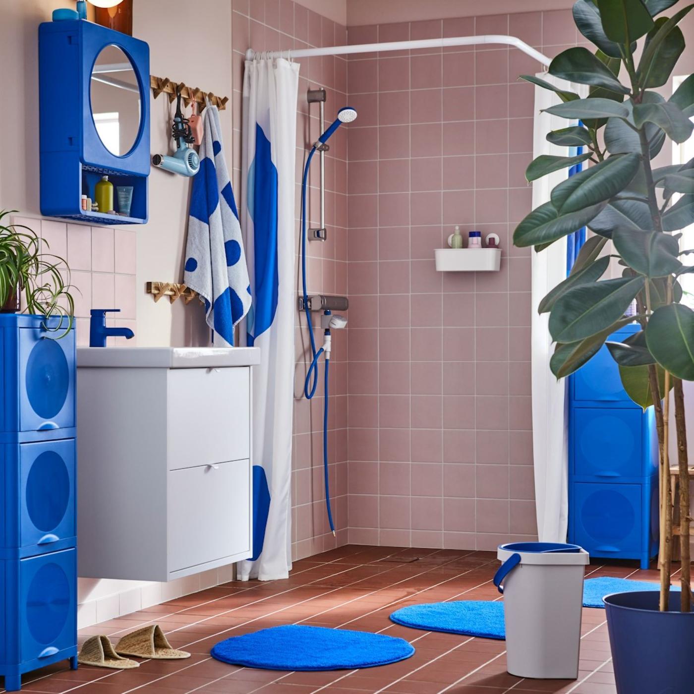 A pink tiled bathroom styled with the BERGVATTNET collection in bright blue and grey.
