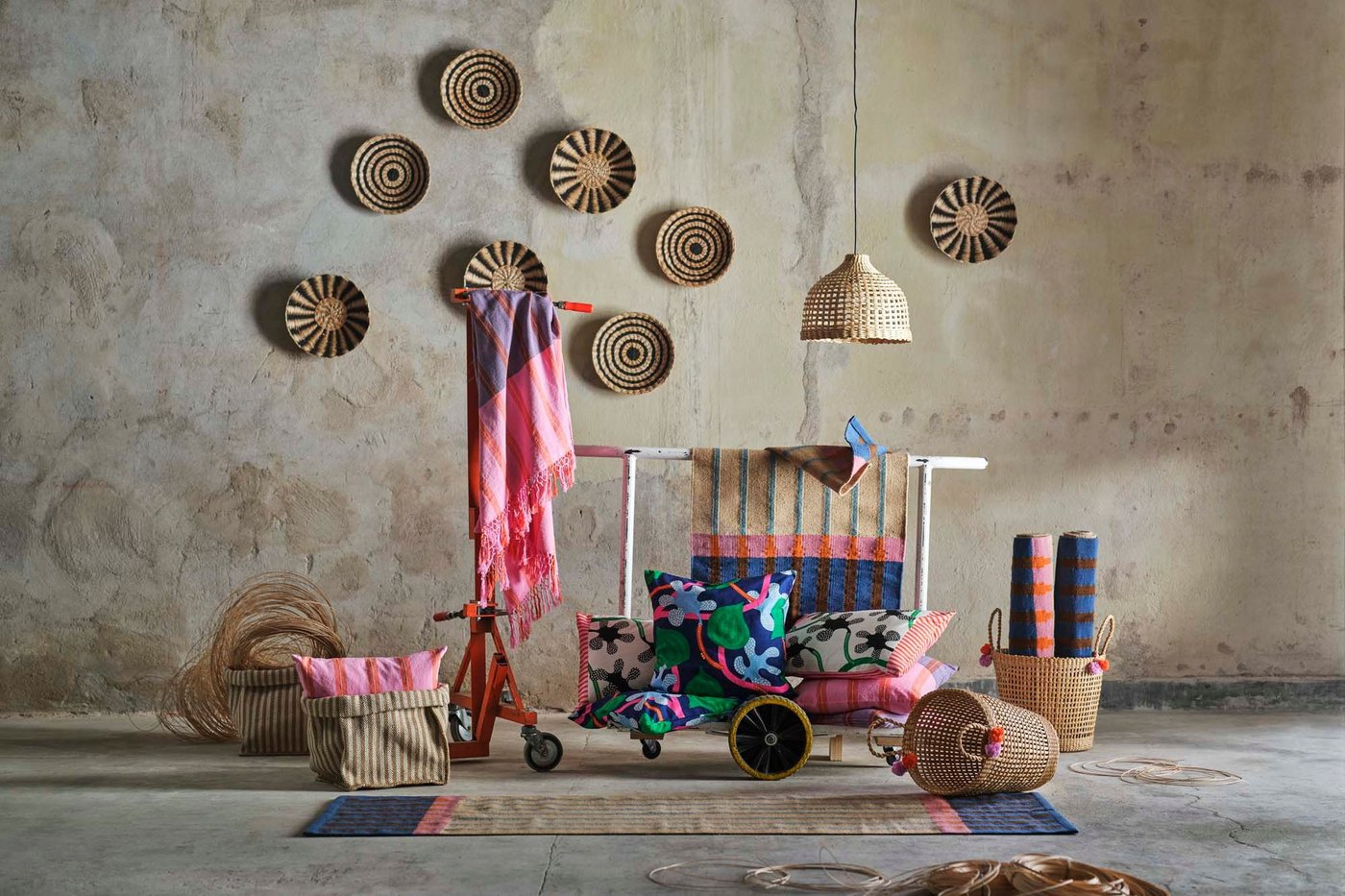 The MÄVINN collection of handmade products arranged on the floor and wall against a rough, warehouse backdrop.