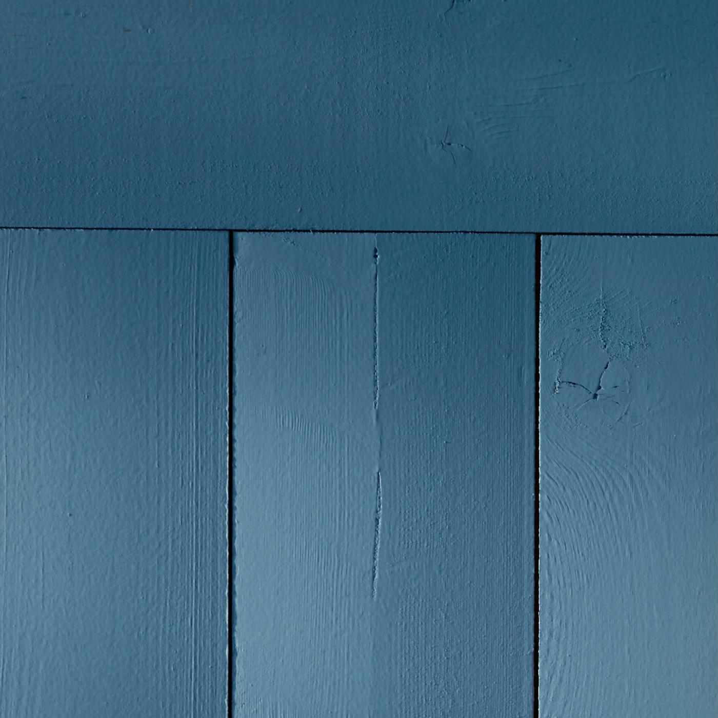 A close-up of a wooden wall painted blue.