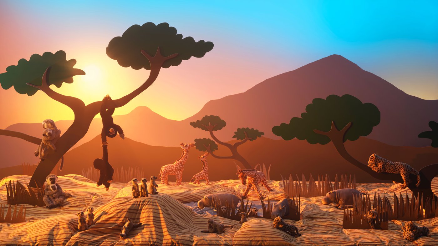 Several different soft toys of which monkeys, giraffes and meercats, all displayed with a backdrop inspired by the African savannah.