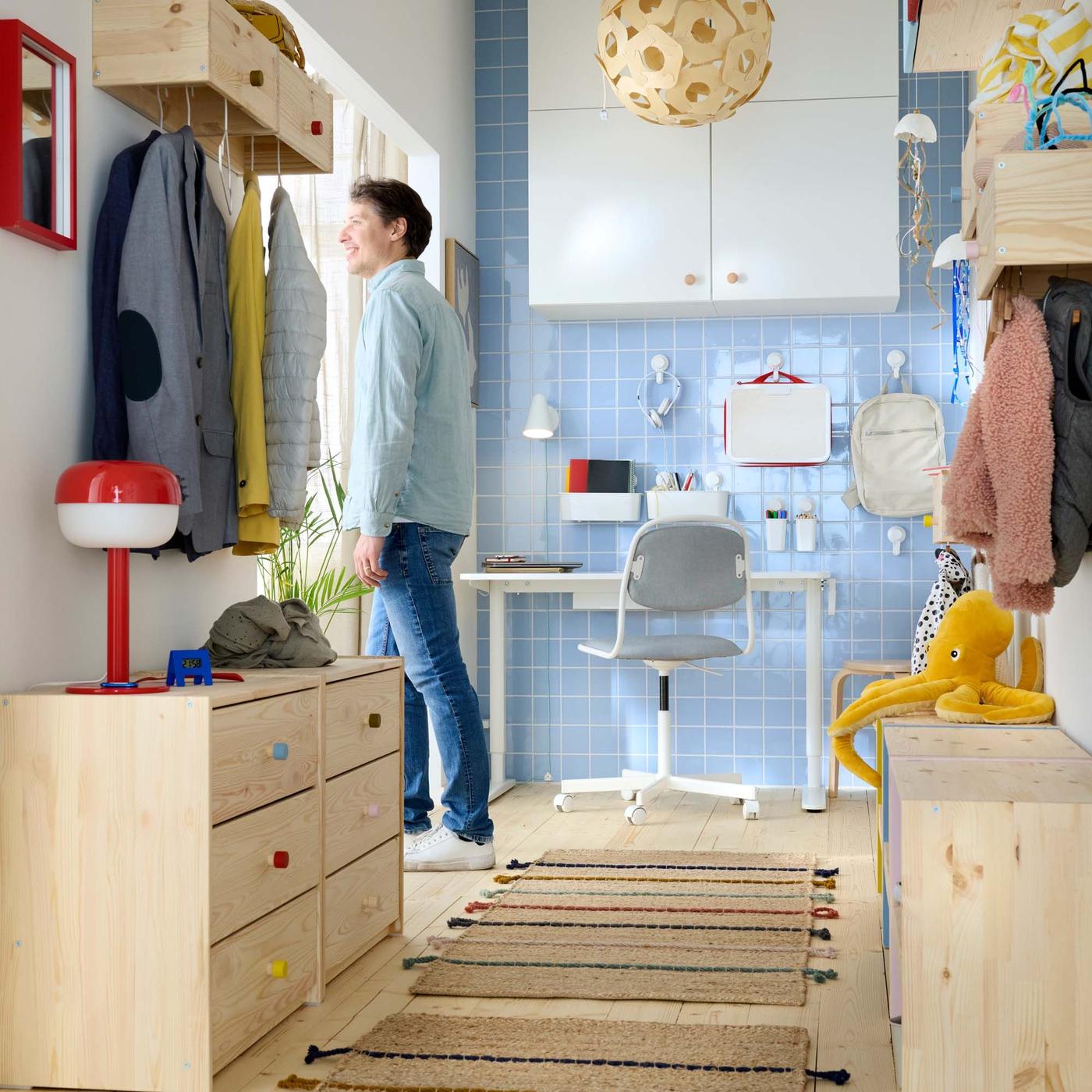 View of a hallway with a desk area at the end. A person is seen exiting the hallway.