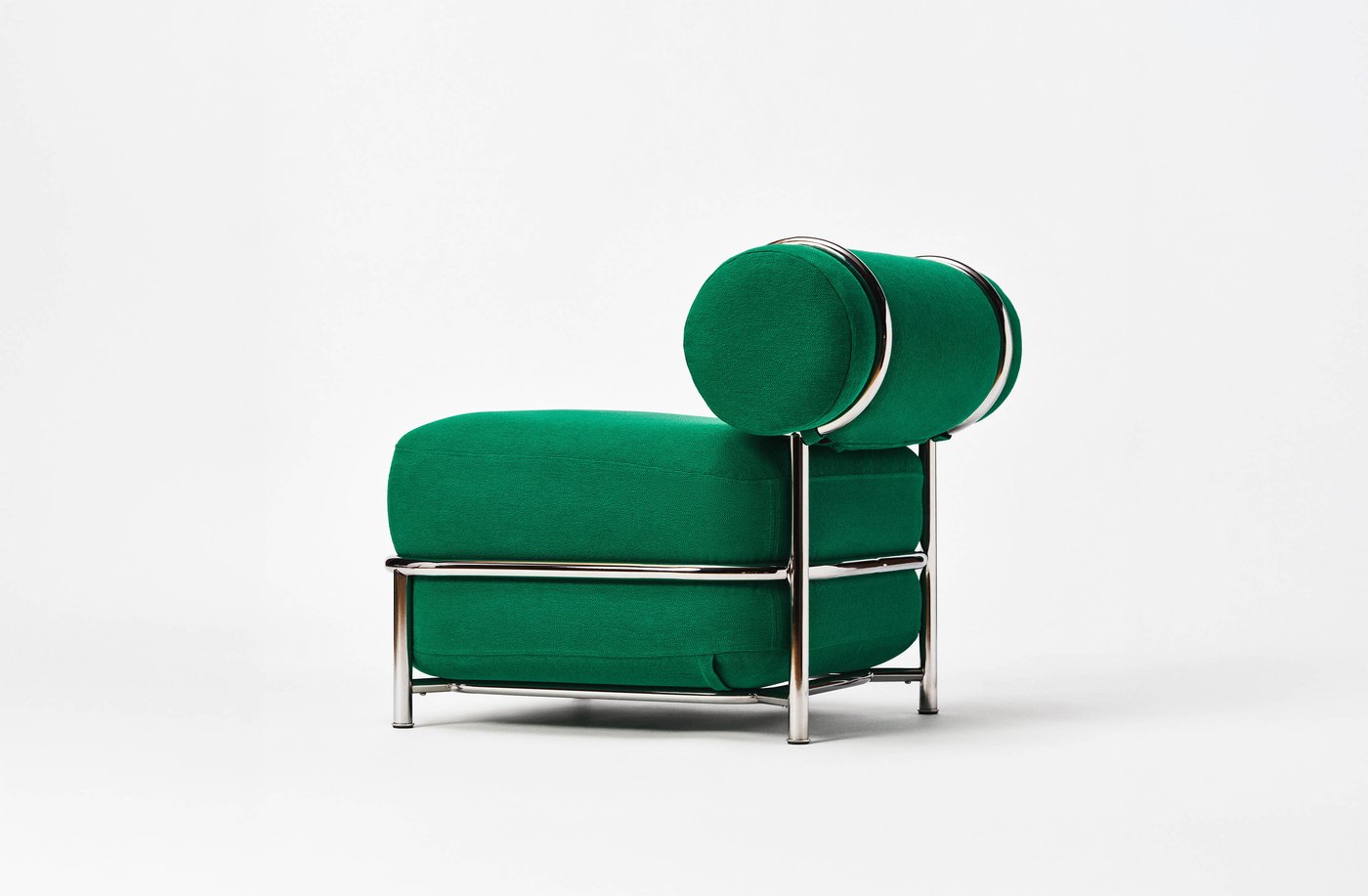Green air-filled upholstered lounge chair with cylindrical back cushions and a polished metal frame, photographed against a white background.