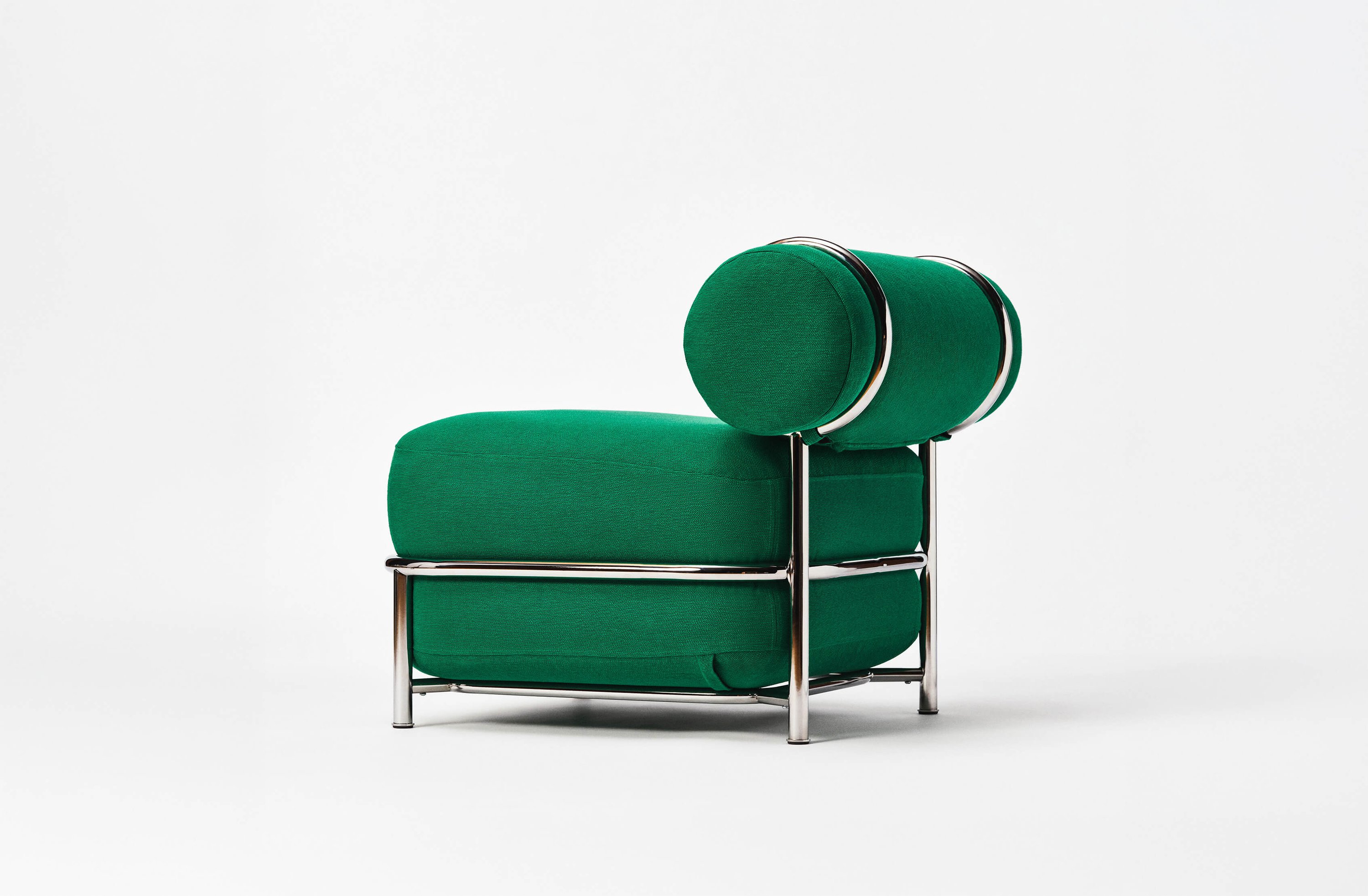Green air-filled upholstered lounge chair with cylindrical back cushions and a polished metal frame, photographed against a white background.