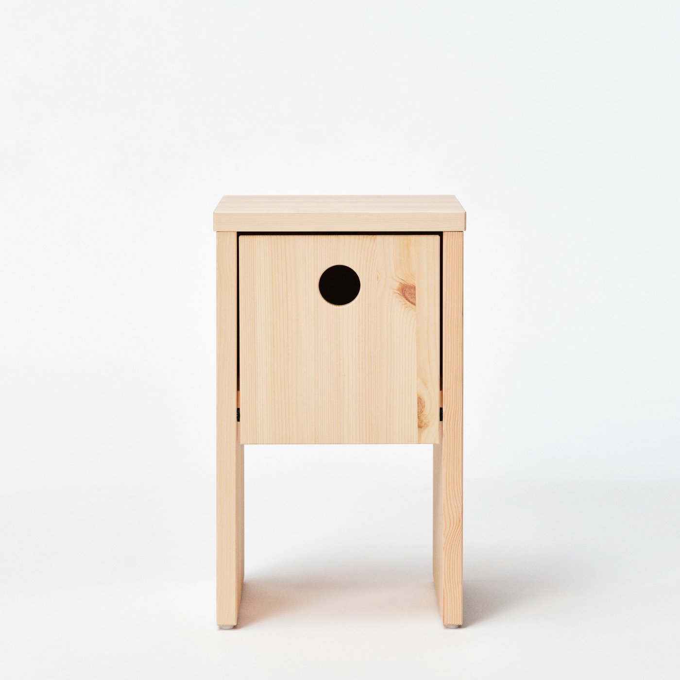 A coffee table with a hole in the front similar to a bird's nest is standing against a white neutral background.