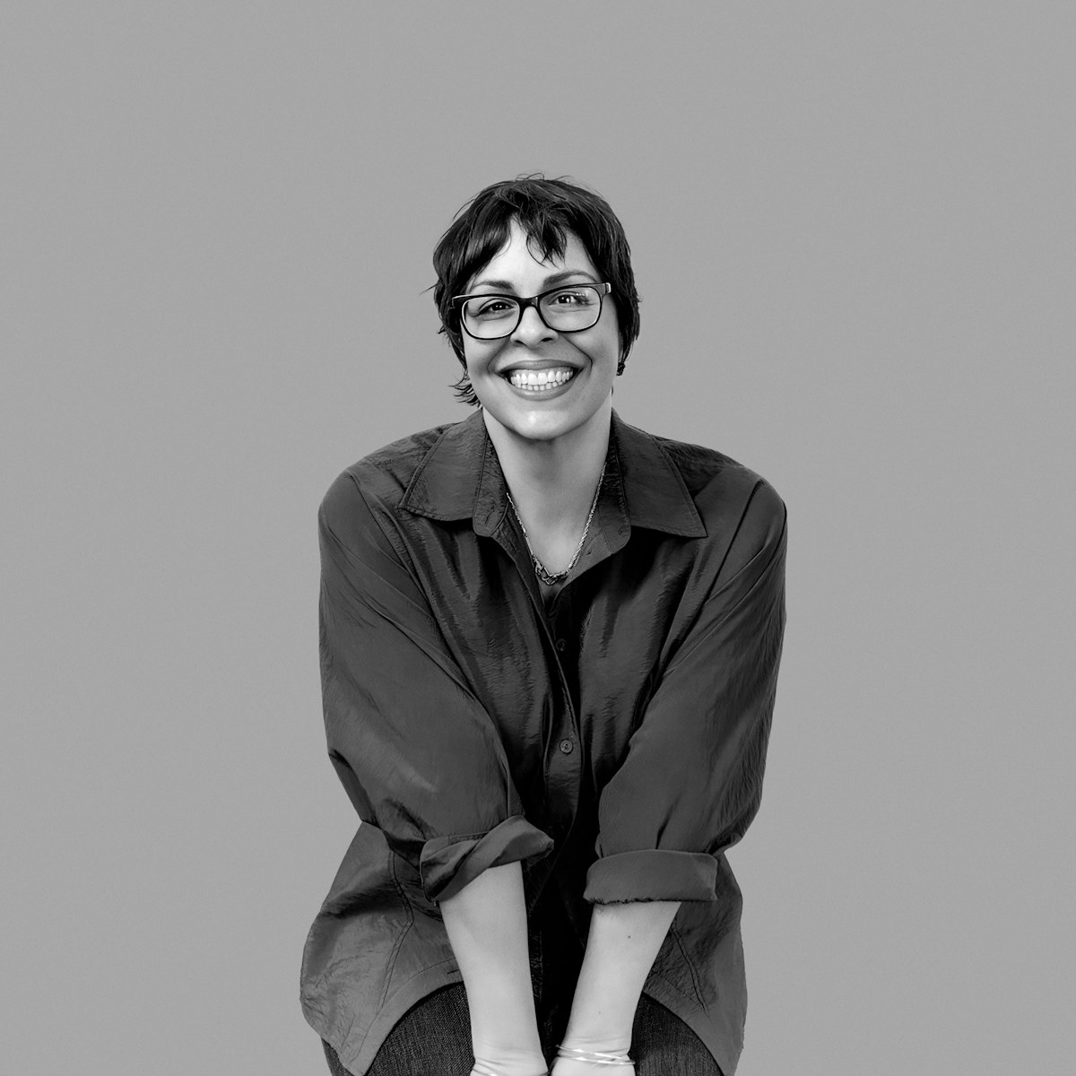 A black and white image of Michelle Armas smiling at the camera.