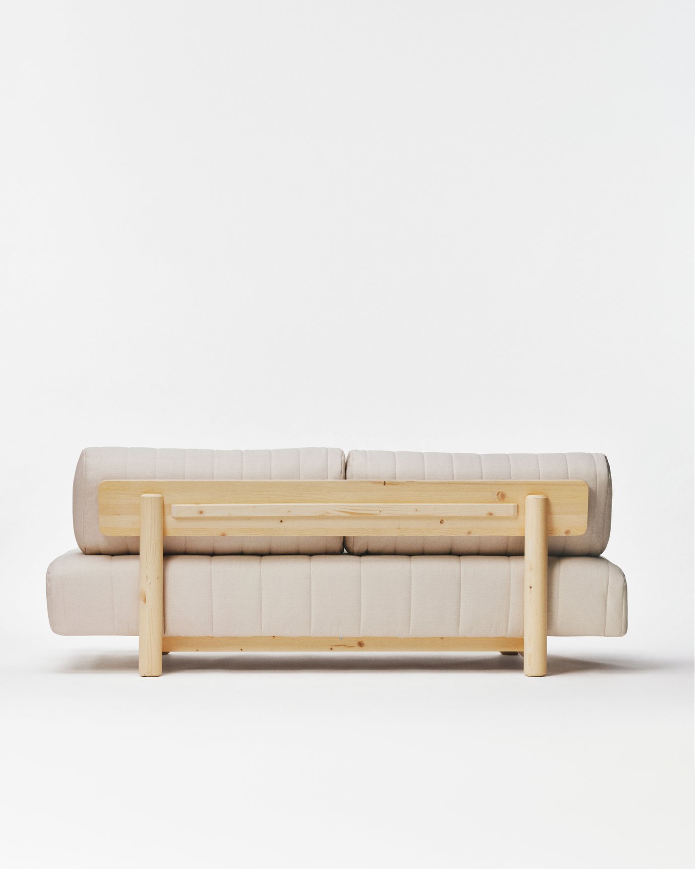 The back view of a beige sofa bed from the IKEA PS 2026 collection, against a white backdrop.