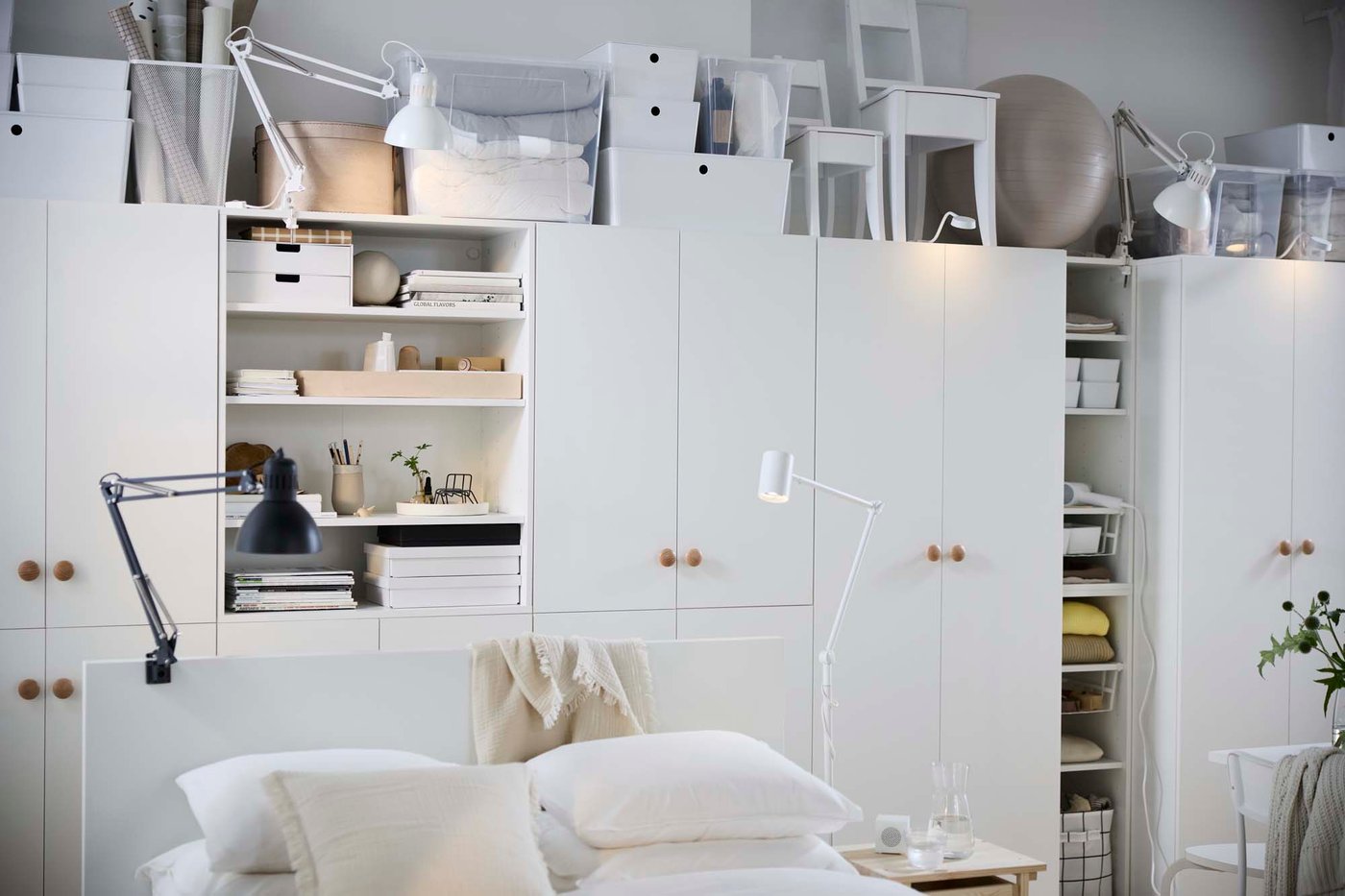 A white wall-to-wall storage system with open and closed storage.