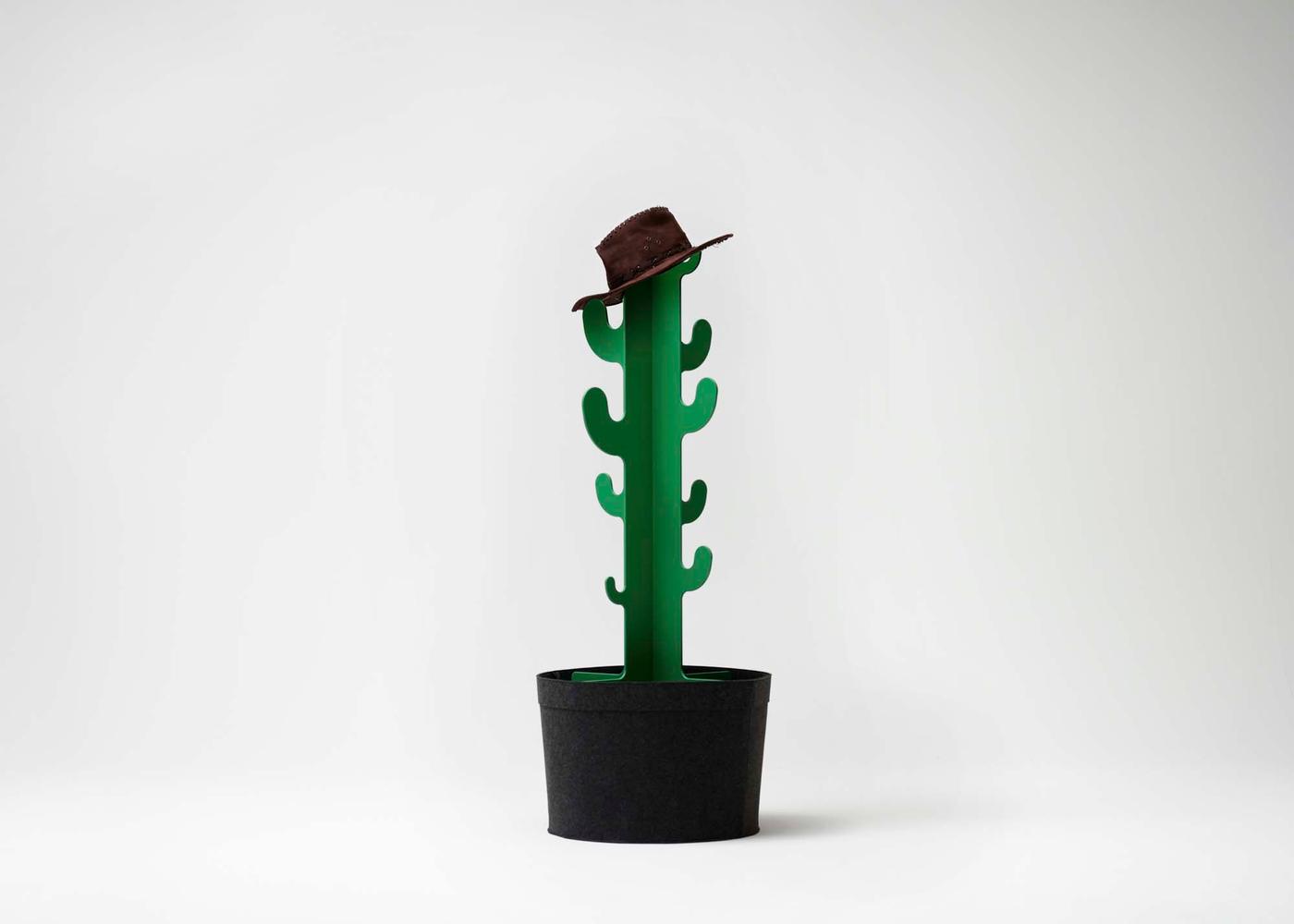 A cowboy hat atop a green cactus-shaped GREJSIMOJS clothes stand in a white environment.