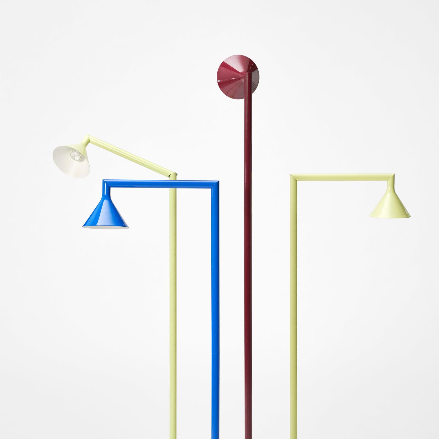 A red, blue and two yellow PS 2026 uplighter lamps in different positions, against a light background.