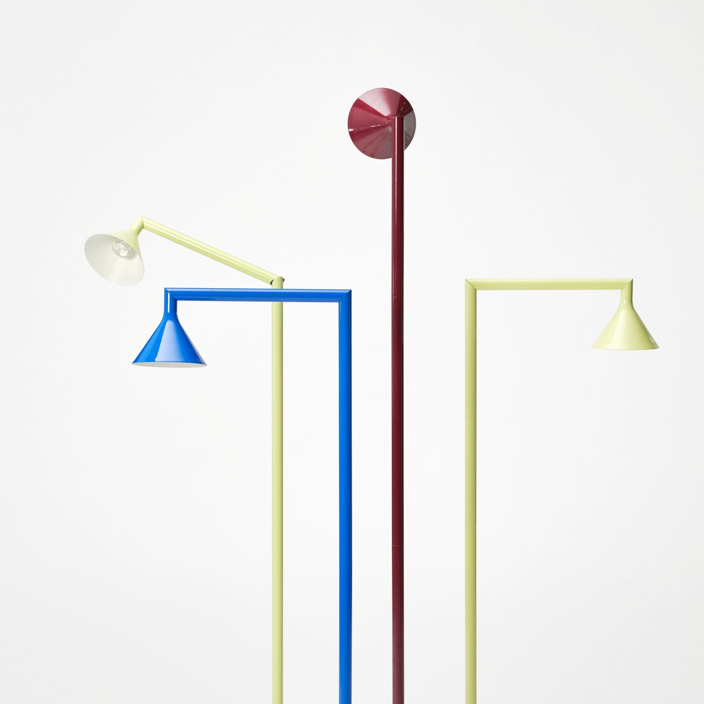 Four slender floor lamps in blue, burguny and two in pale yellow, with angled cone-shaped shades against a white background.
