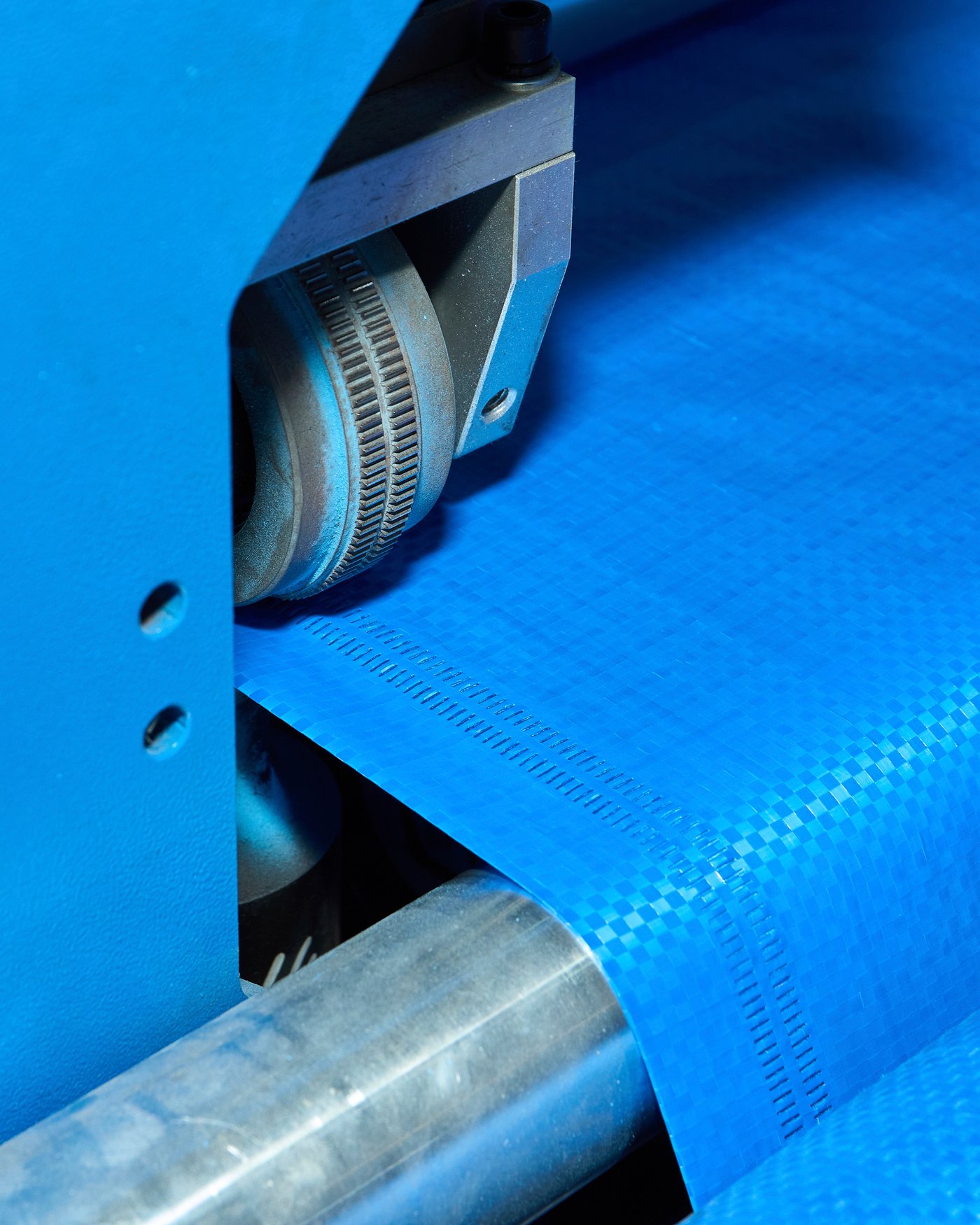A close-up of a roller welding the seams of a FRAKTA bag.