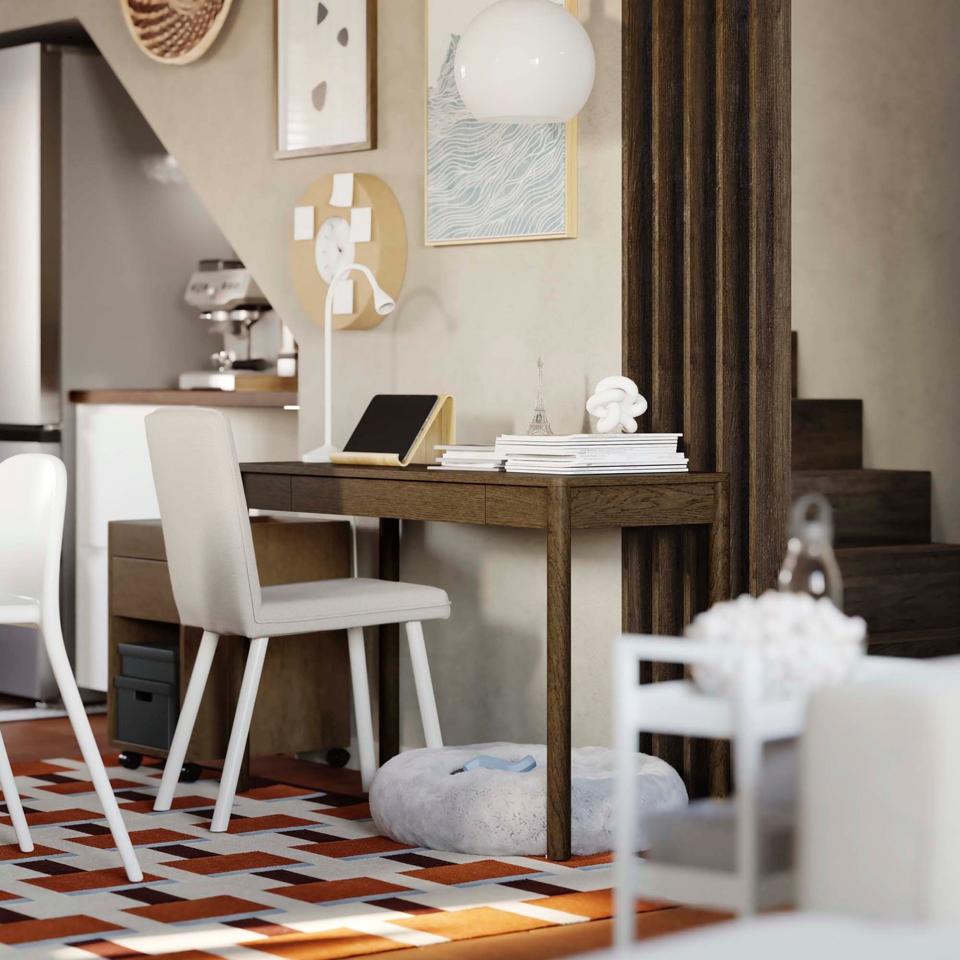 An area near the stairs with a dark wood slim desk in a neutral coloured room.