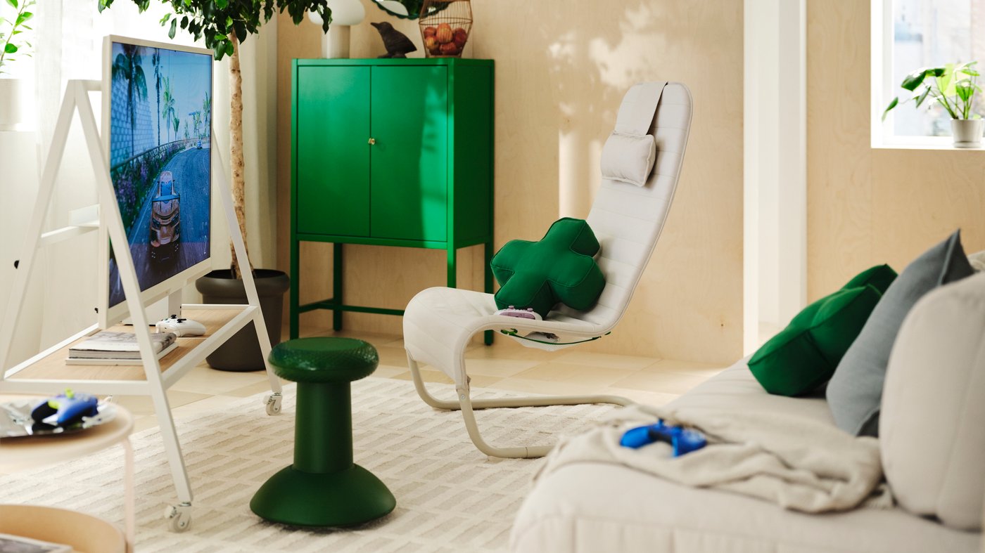 A living room gaming setup with a YXSTABY gaming chair, thumbstick stool, TV stand and D-pad-inspired cushions.