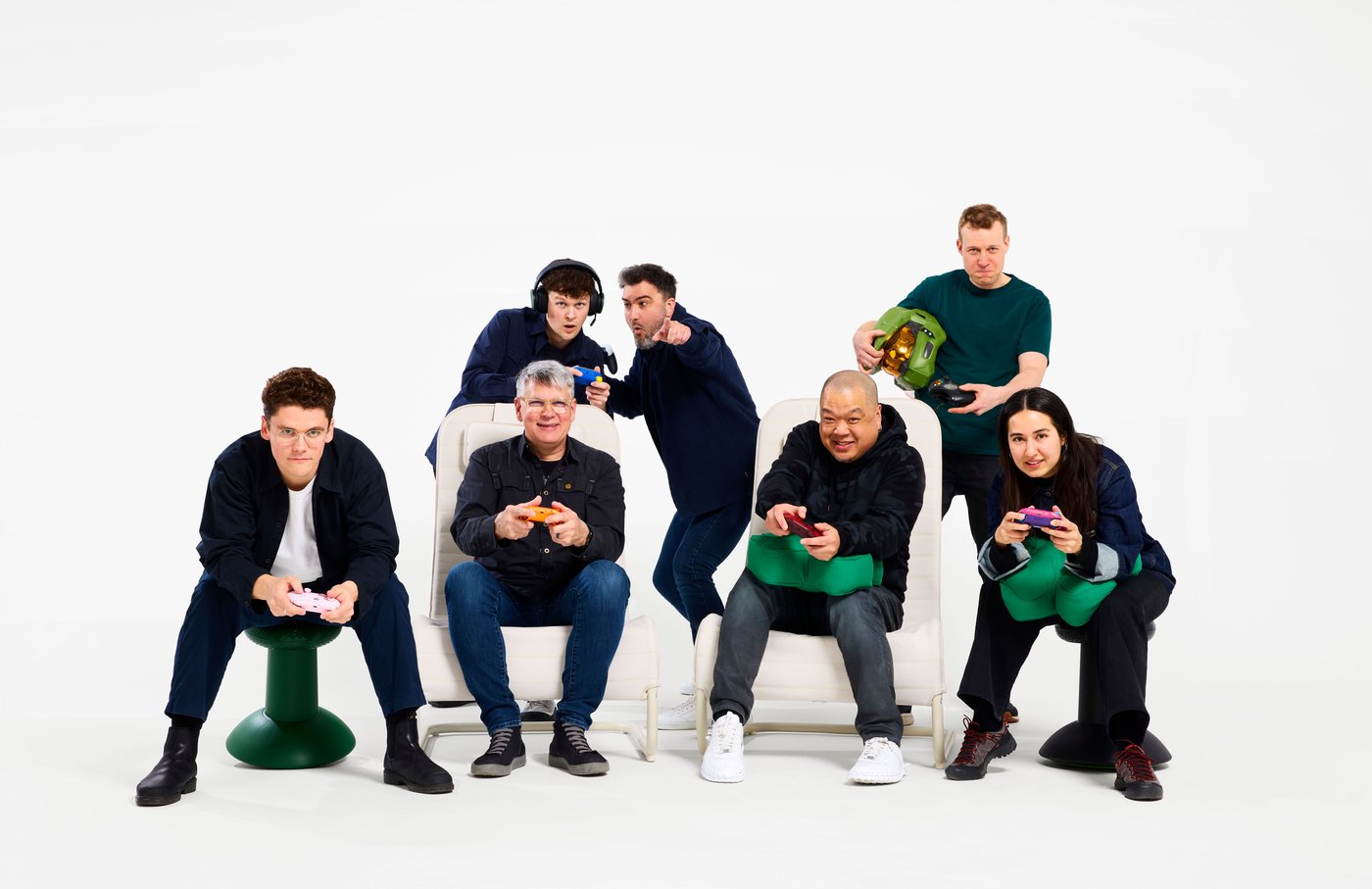 A group photo of the IKEA and XBOX designers sitting with gaming controllers and YXSTABY cushions.