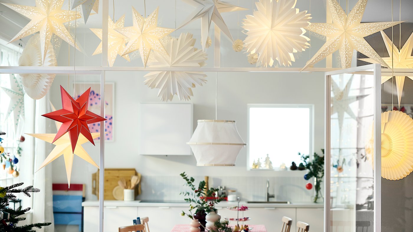 Window decorated with illuminated paper star lamps in various shapes and sizes.